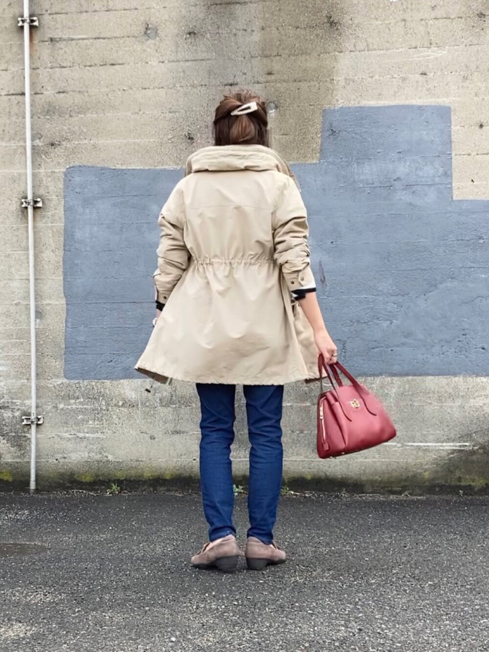 ベージュ系のジャケット/アウター、ホワイト系のニット/セーター、ブラック系のハンドバッグを着用したレディースの春コーディネートの2枚目の写真