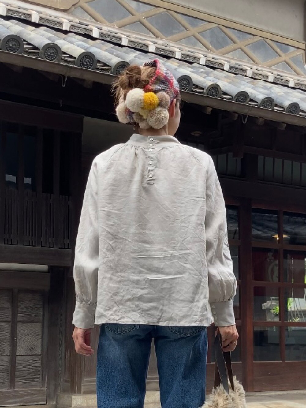 ベージュ系のシャツ/ブラウス、ブルー系のデニムパンツ、ブラウン系のブーツを着用したレディースの秋コーディネートの4枚目の写真