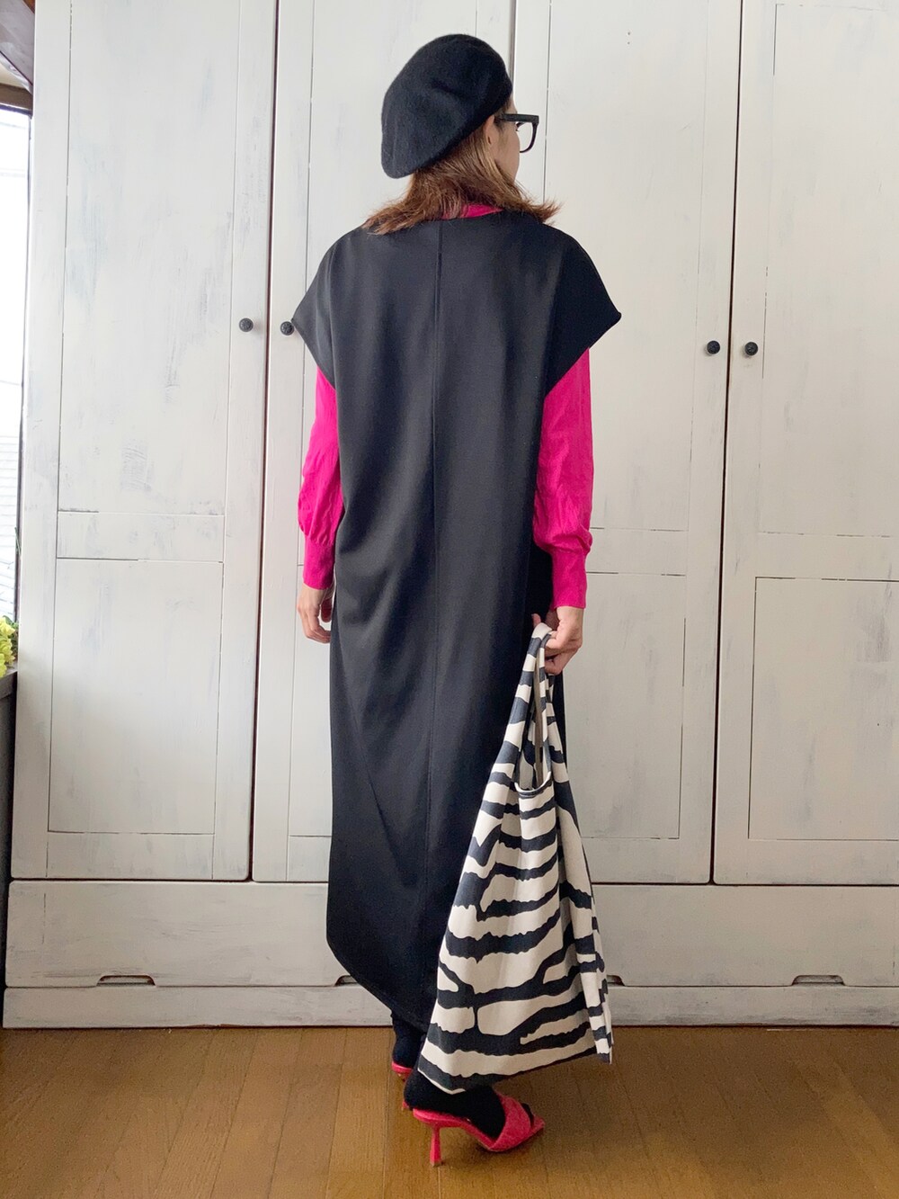 ブラック系のワンピース、ピンク系のカーディガン/ボレロ、その他のトートバッグを着用したレディースの秋コーディネートの2枚目の写真