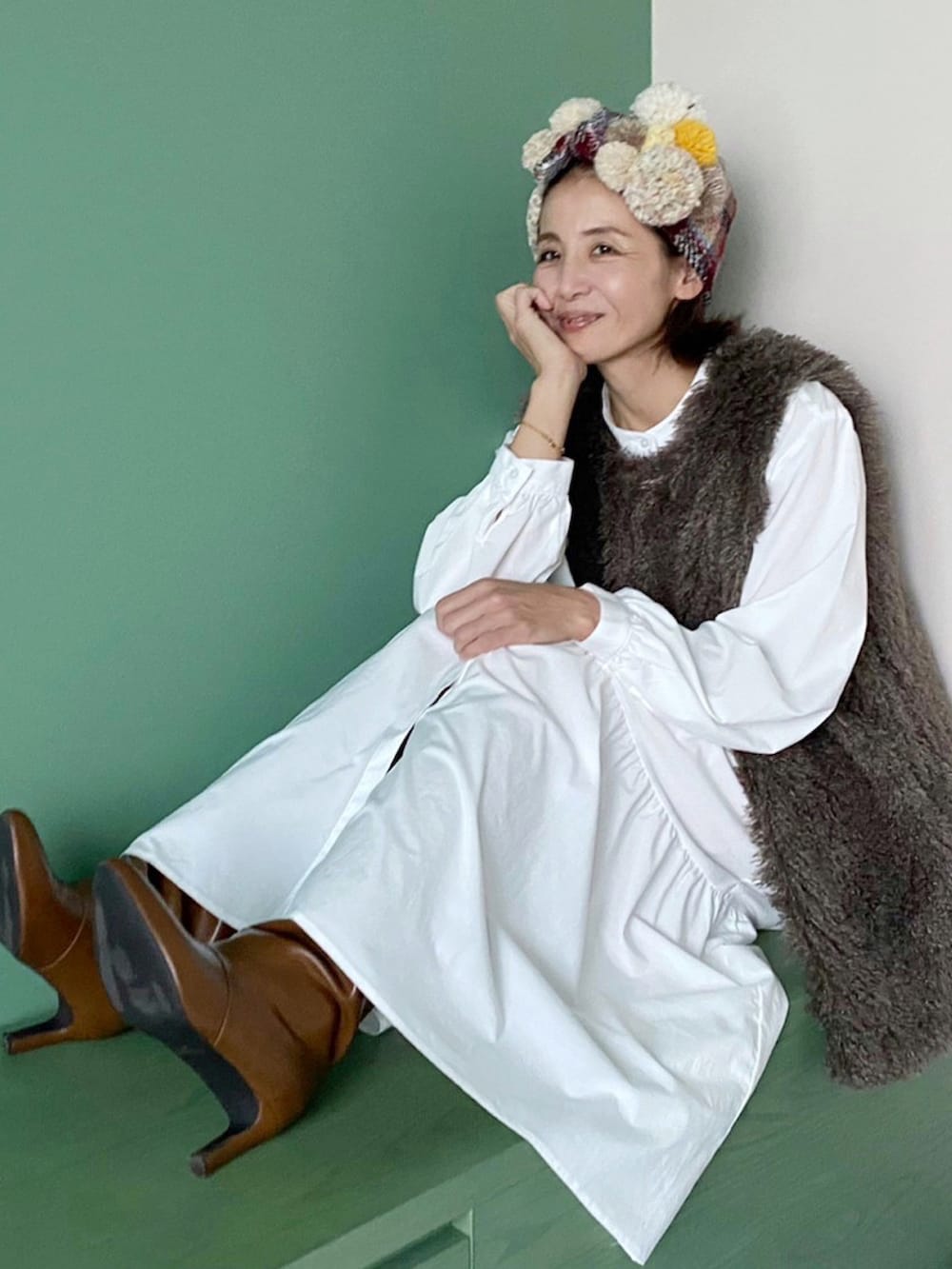 グレー系のベスト、イエロー系のブーツ、ベージュ系のヘアバンドを着用したレディースの秋コーディネートの4枚目の写真