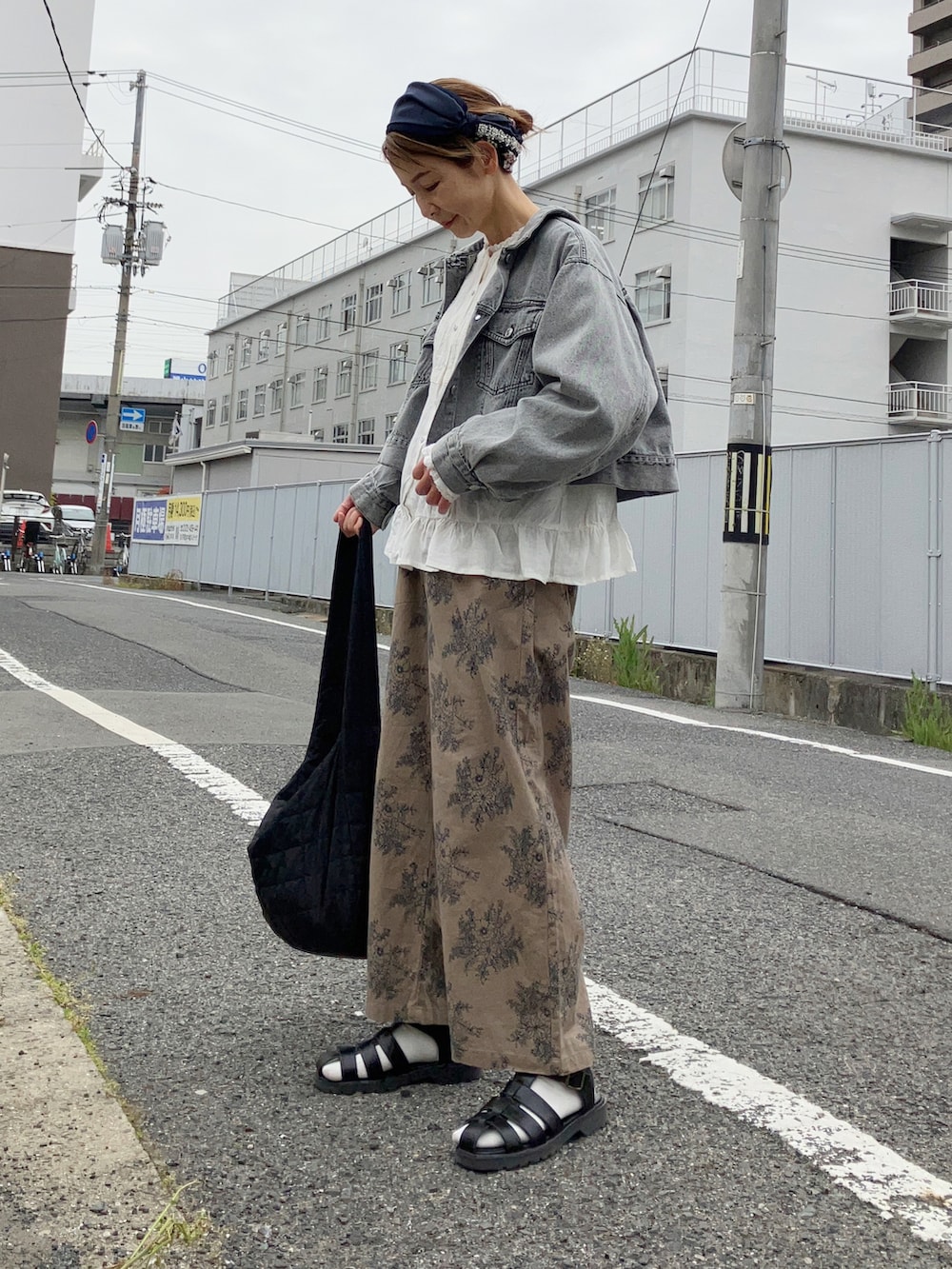 ベージュ系のパンツ、ブラック系のデニムジャケット、ホワイト系のシャツ/ブラウスを着用したレディースの春コーディネートの3枚目の写真