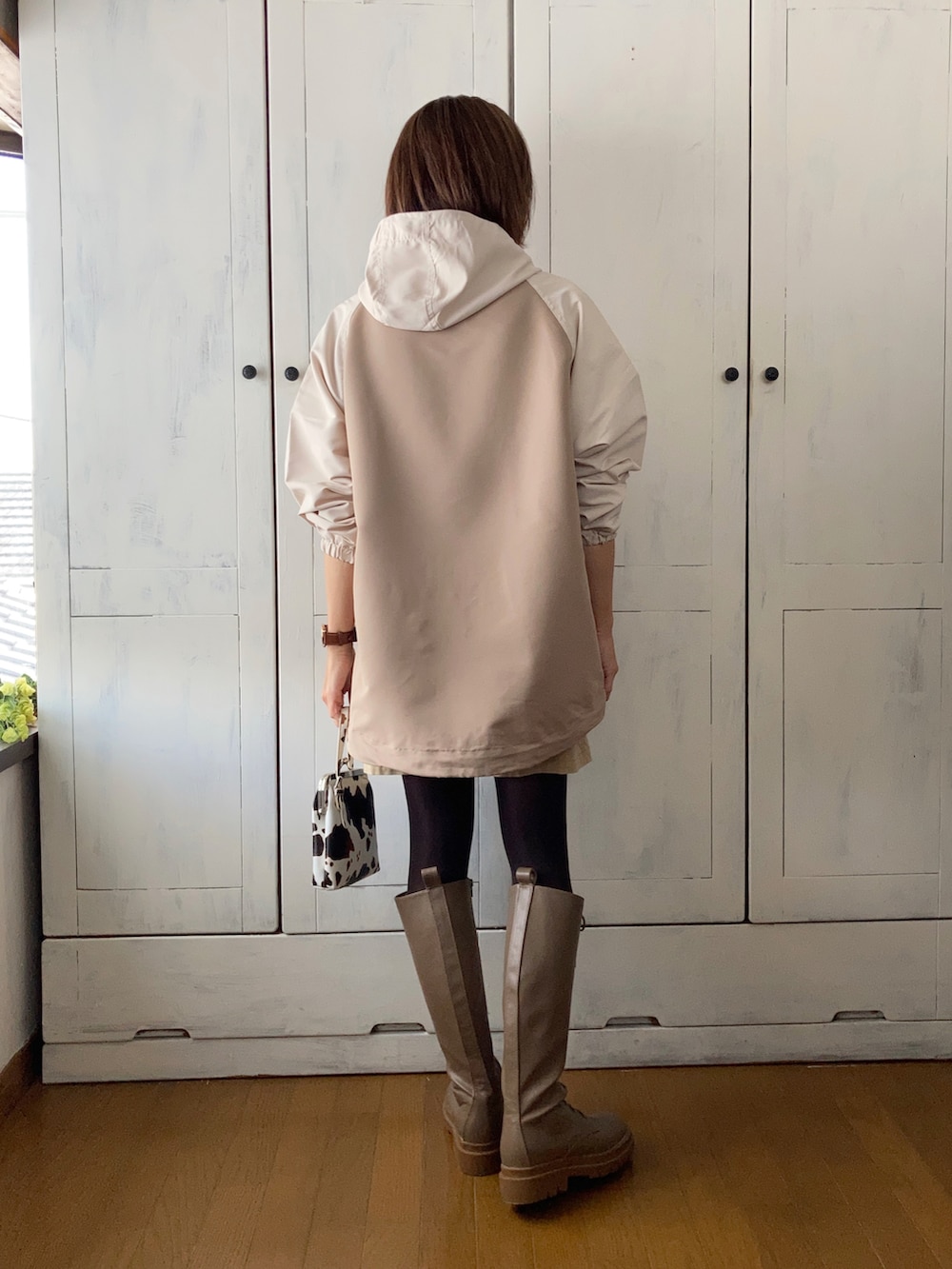 ベージュ系のマウンテンパーカー、ベージュ系のベスト、ベージュ系のスカートを着用したレディースの秋コーディネートの3枚目の写真