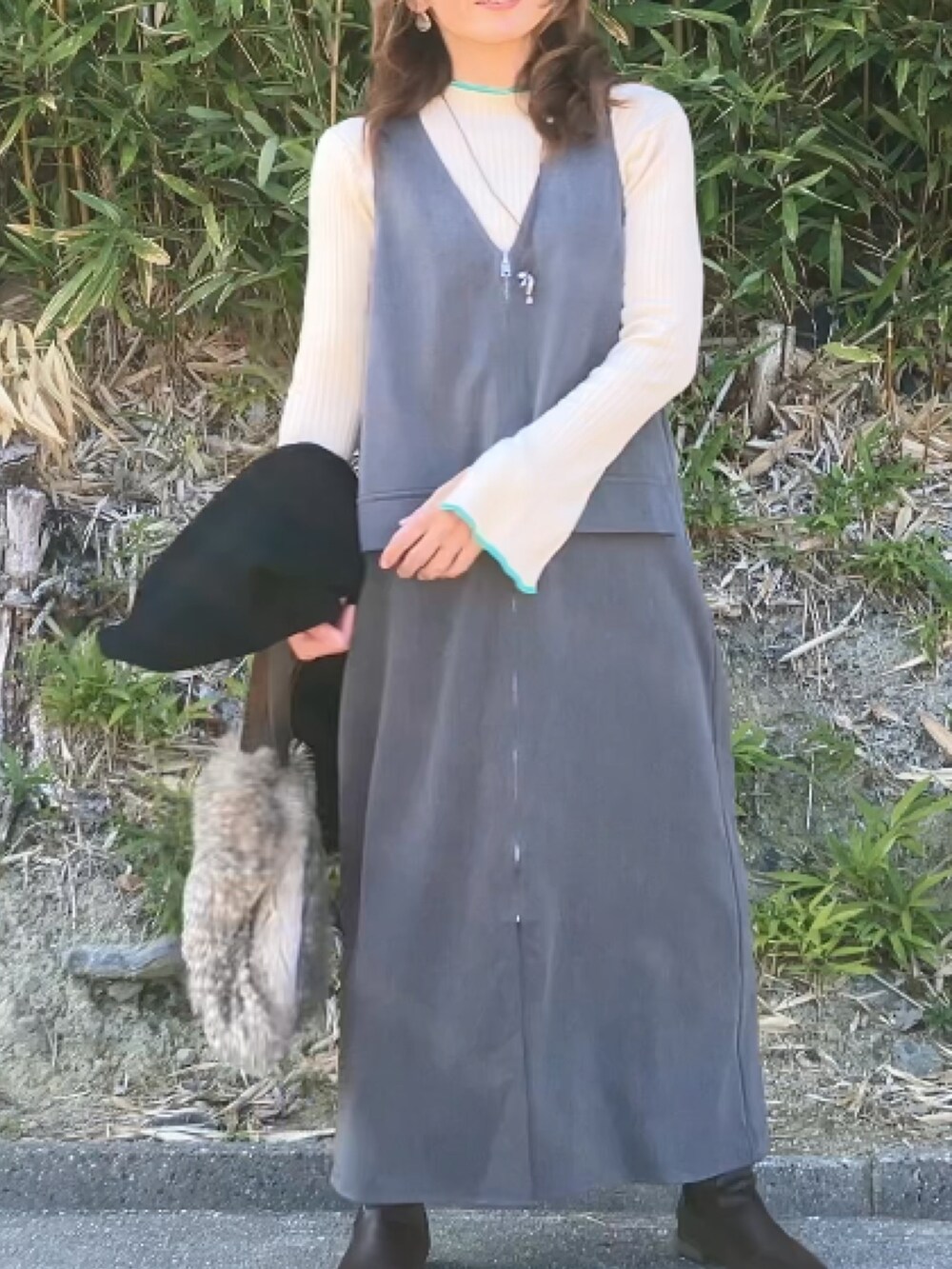 グレー系のワンピース、ホワイト系のニット/セーターを着用したレディースの冬コーディネートの3枚目の写真