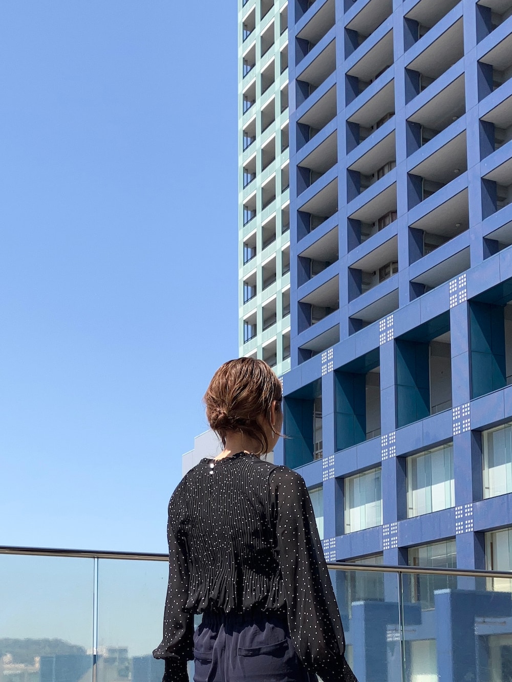 ブルー系のスーツセット、ブラック系のシャツ/ブラウス、ブラック系のビジネスバッグを着用したレディースの春コーディネートの2枚目の写真