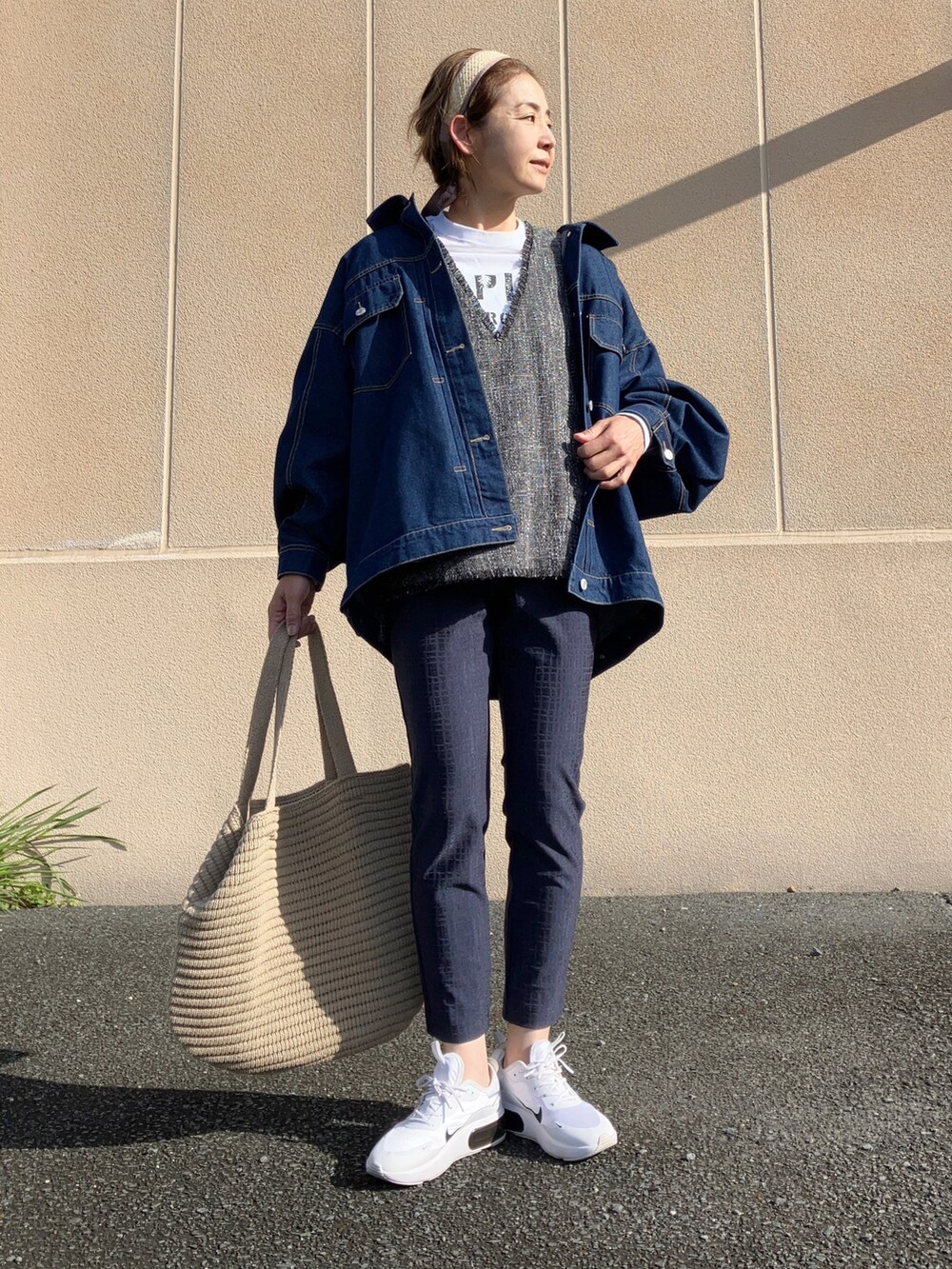 グレー系のベスト、ホワイト系のTシャツ/カットソー、ブルー系のデニムジャケットを着用したレディースの春コーディネートの2枚目の写真