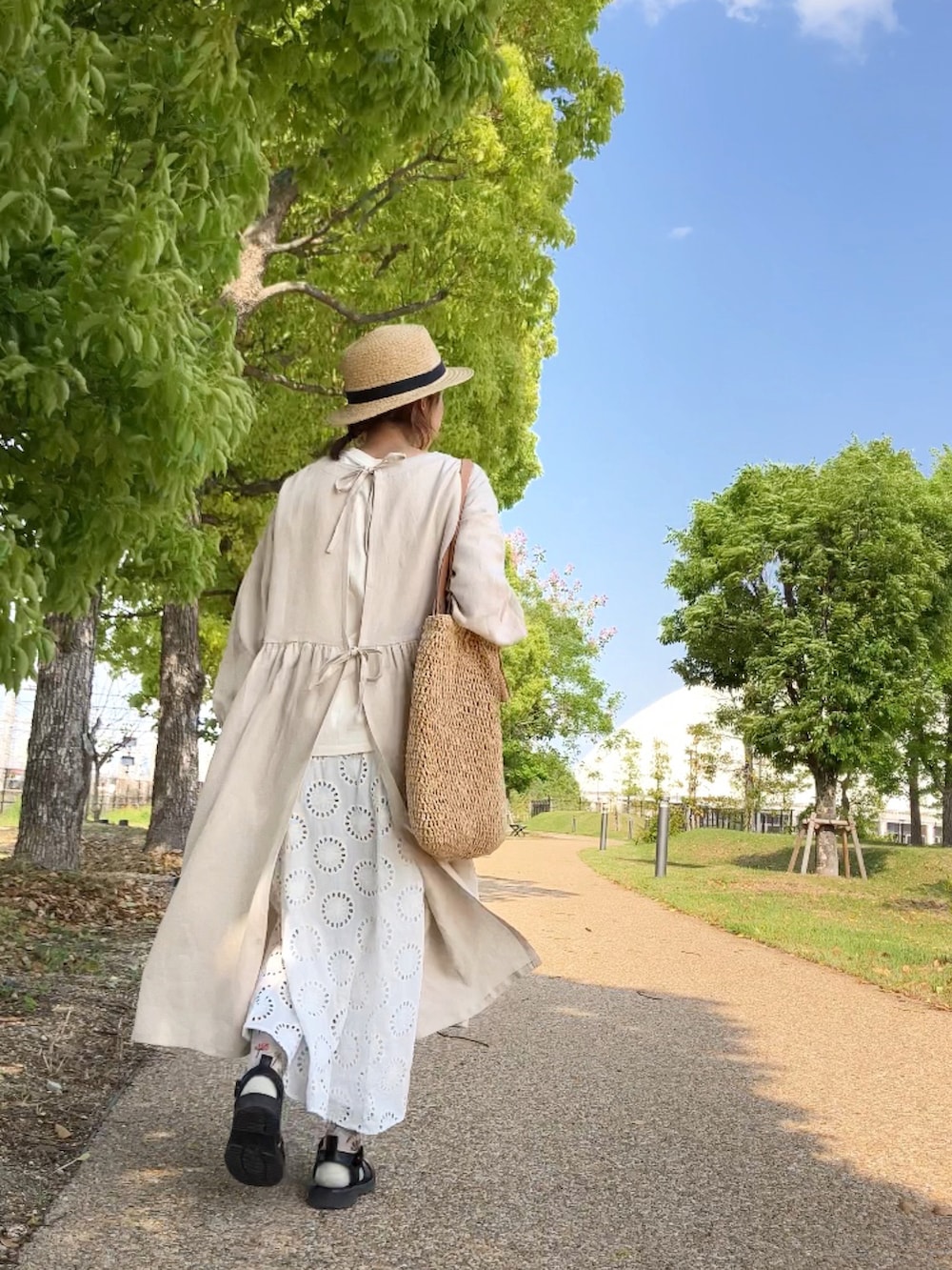 ホワイト系のTシャツ/カットソー、ホワイト系のワンピース/ドレス、ベージュ系のバッグを着用したレディースの春コーディネートの4枚目の写真