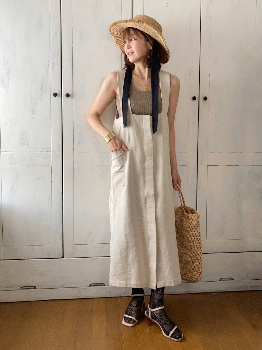 ベージュ系のジャンパースカート、ベージュ系のバッグ、ベージュ系のサンダルを着用したレディースの春コーディネートの3枚目の写真