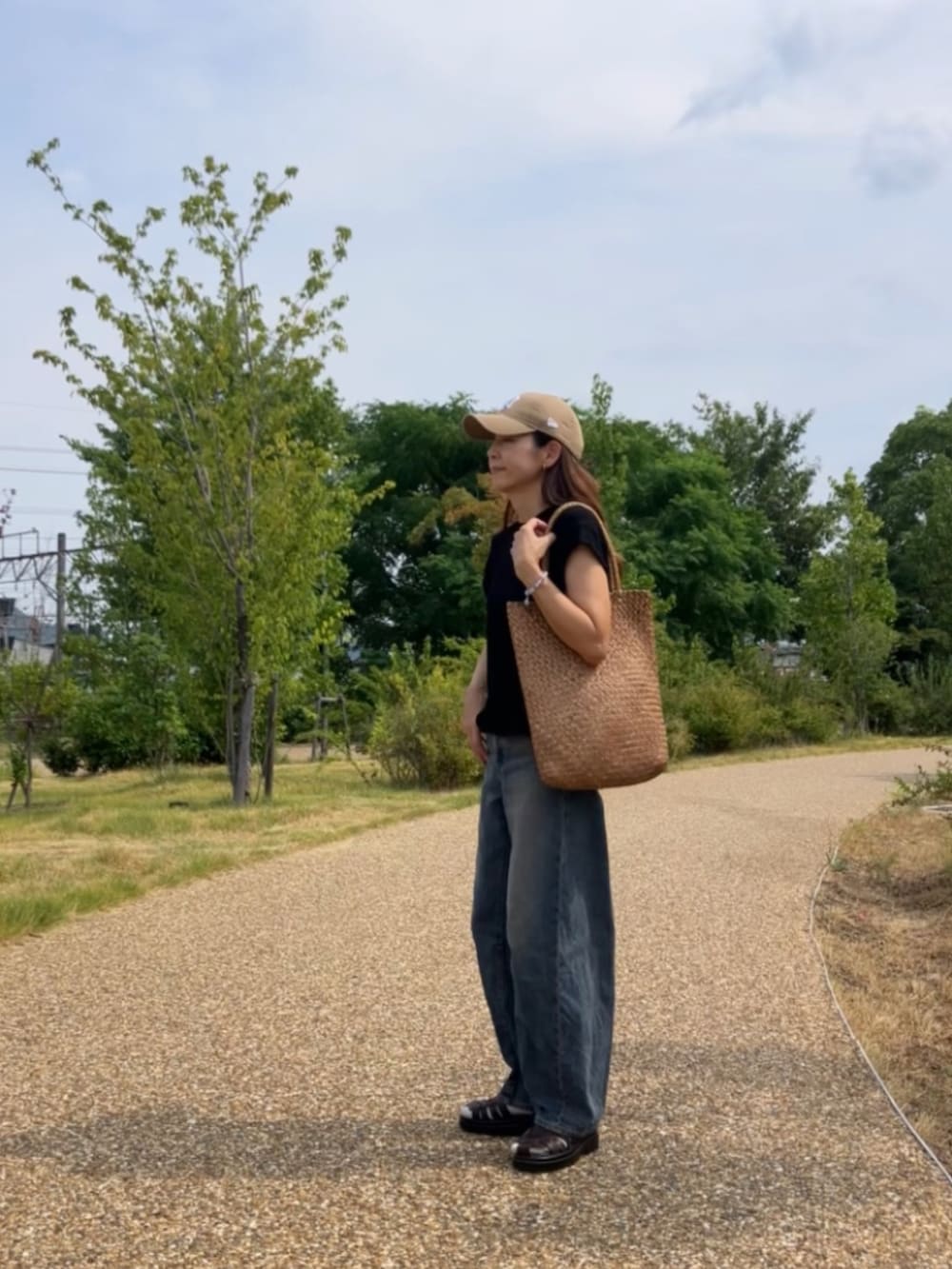 ブラック系のTシャツ/カットソー、ブラウン系のバッグ、ベージュ系のキャップを着用したレディースの夏コーディネートの5枚目の写真