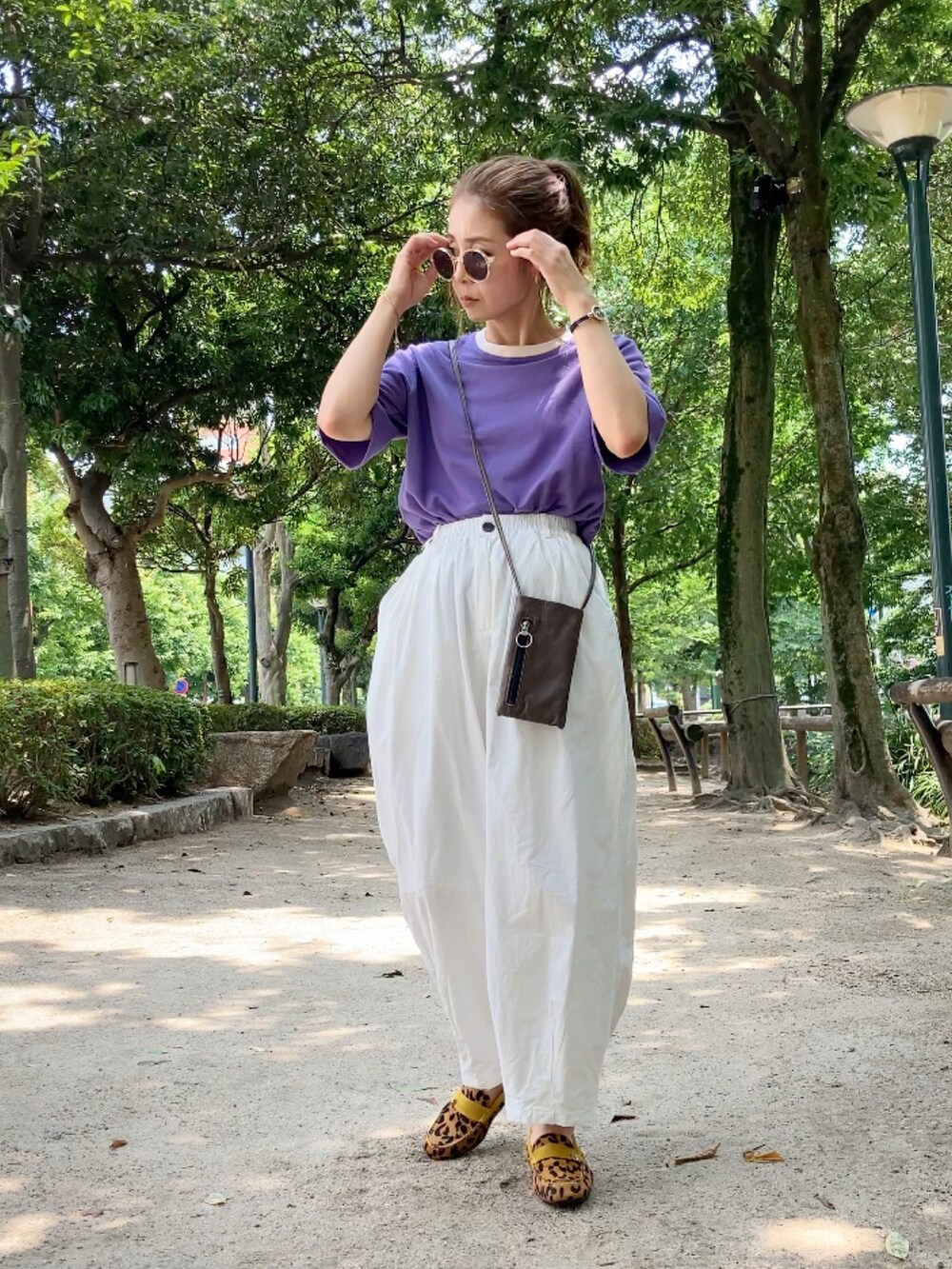 パープル系のTシャツ/カットソー、ホワイト系のチノパンツ、グリーン系のショルダーバッグを着用したレディースの夏コーディネートの3枚目の写真