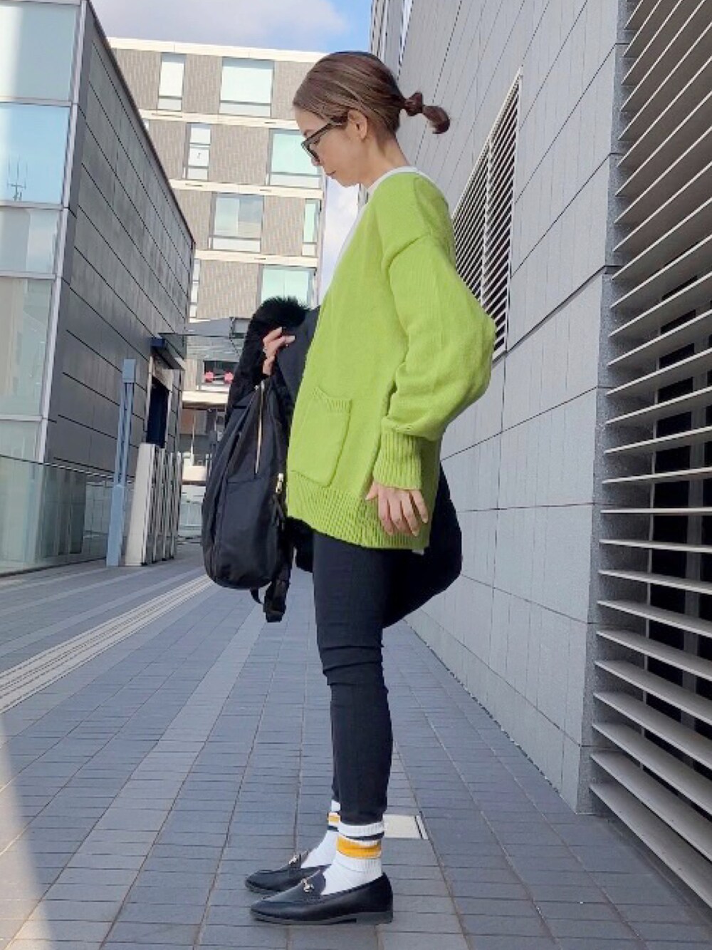 ブラック系のブルゾン、グリーン系のカーディガン/ボレロ、ブラック系のパンツを着用したレディースの冬コーディネートの4枚目の写真