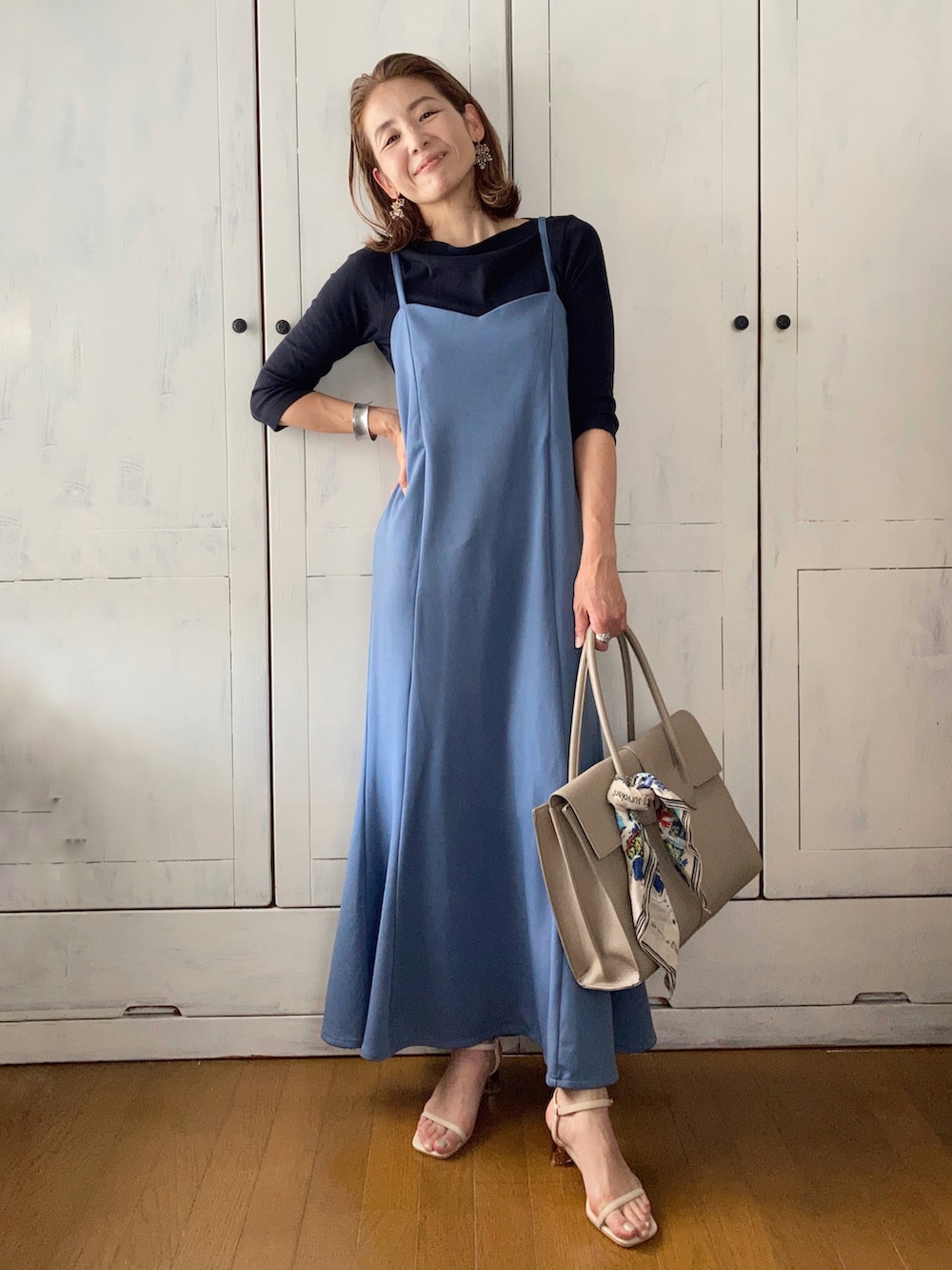ブルー系のワンピース、ベージュ系のビジネスバッグ、ベージュ系のサンダルを着用したレディースの夏コーディネートの3枚目の写真