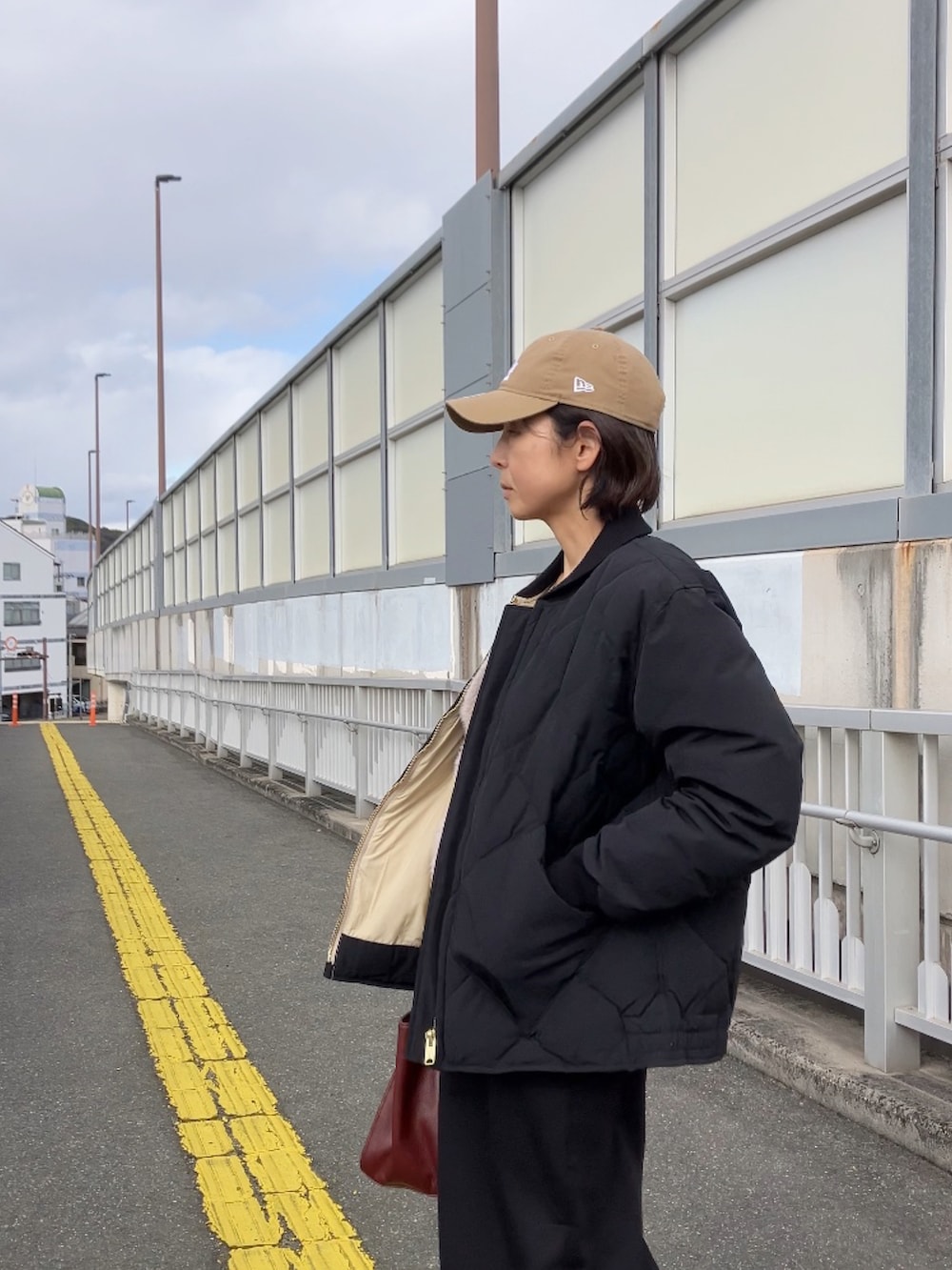 ブラック系のダウンジャケット/コート、ベージュ系のキャップを着用したレディースの冬コーディネートの2枚目の写真