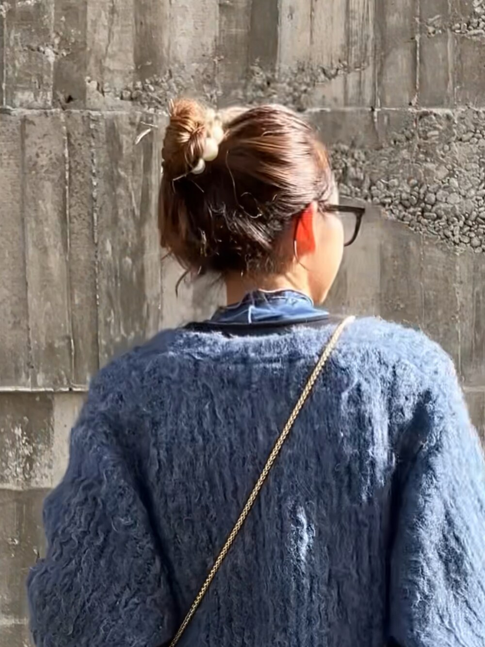 ブルー系のTシャツ/カットソー、ブラック系のジャンパースカート、ブルー系のカーディガン/ボレロを着用したレディースの冬コーディネートの3枚目の写真