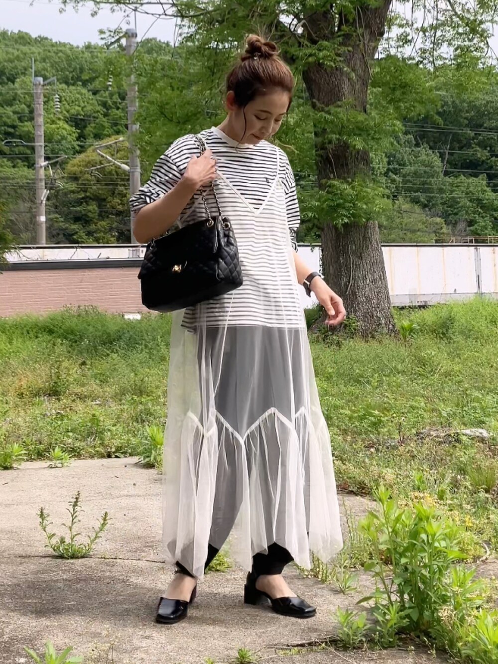 ホワイト系のワンピース、ブラック系のスウェットパンツ、ブラック系のTシャツ/カットソーを着用したレディースの春コーディネートの3枚目の写真