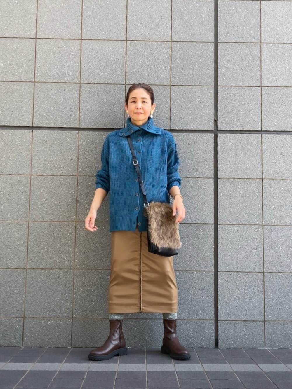 ブラウン系のブーツ、ブラウン系のスカート、ブルー系のニット/セーターを着用したレディースの秋コーディネートの5枚目の写真