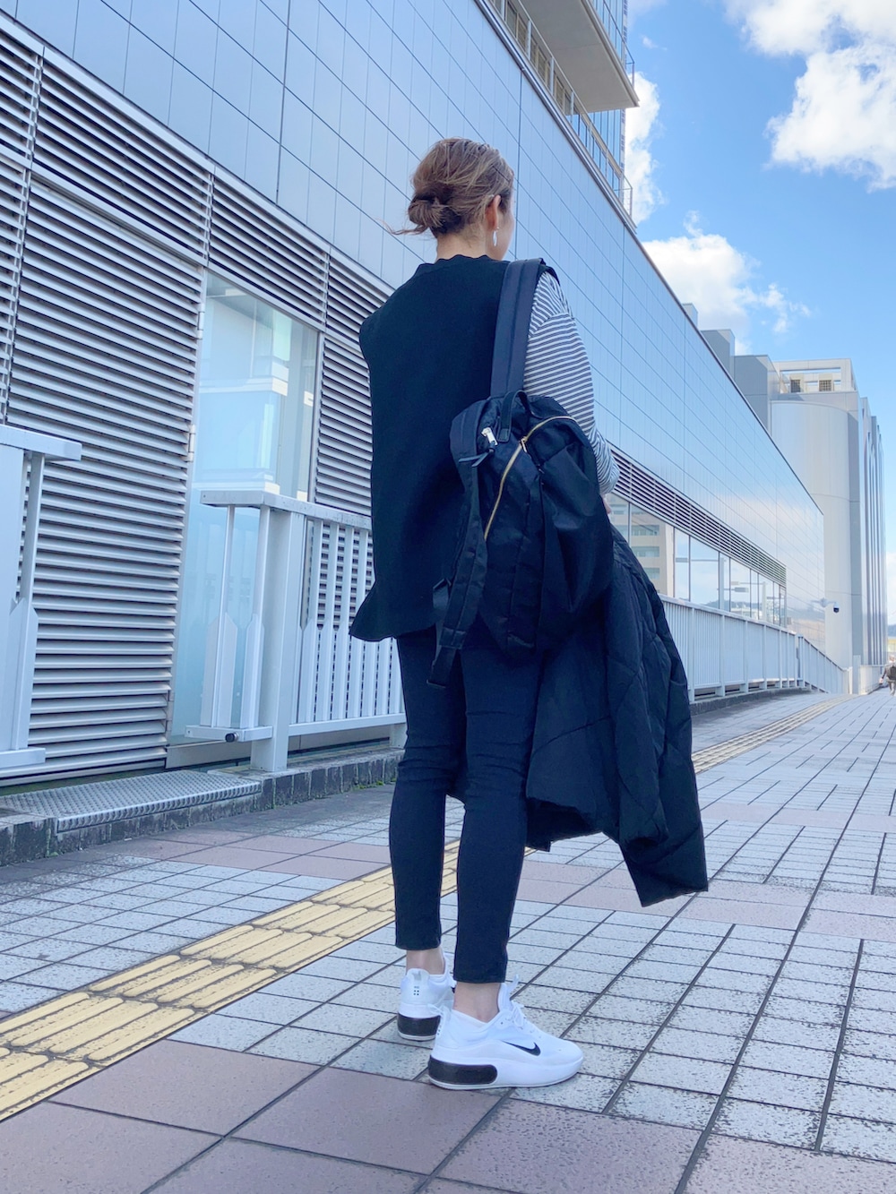 ブラック系のベスト、ブラック系のTシャツ/カットソー、ブラック系のダウンジャケット/コートを着用したレディースの春コーディネートの3枚目の写真