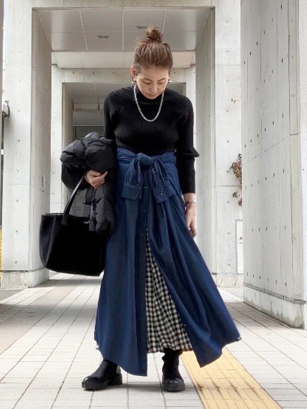 ブルー系のワンピース/ドレス、ブラック系のニット/セーター、ブラック系のスカートを着用したレディースの冬コーディネートの2枚目の写真