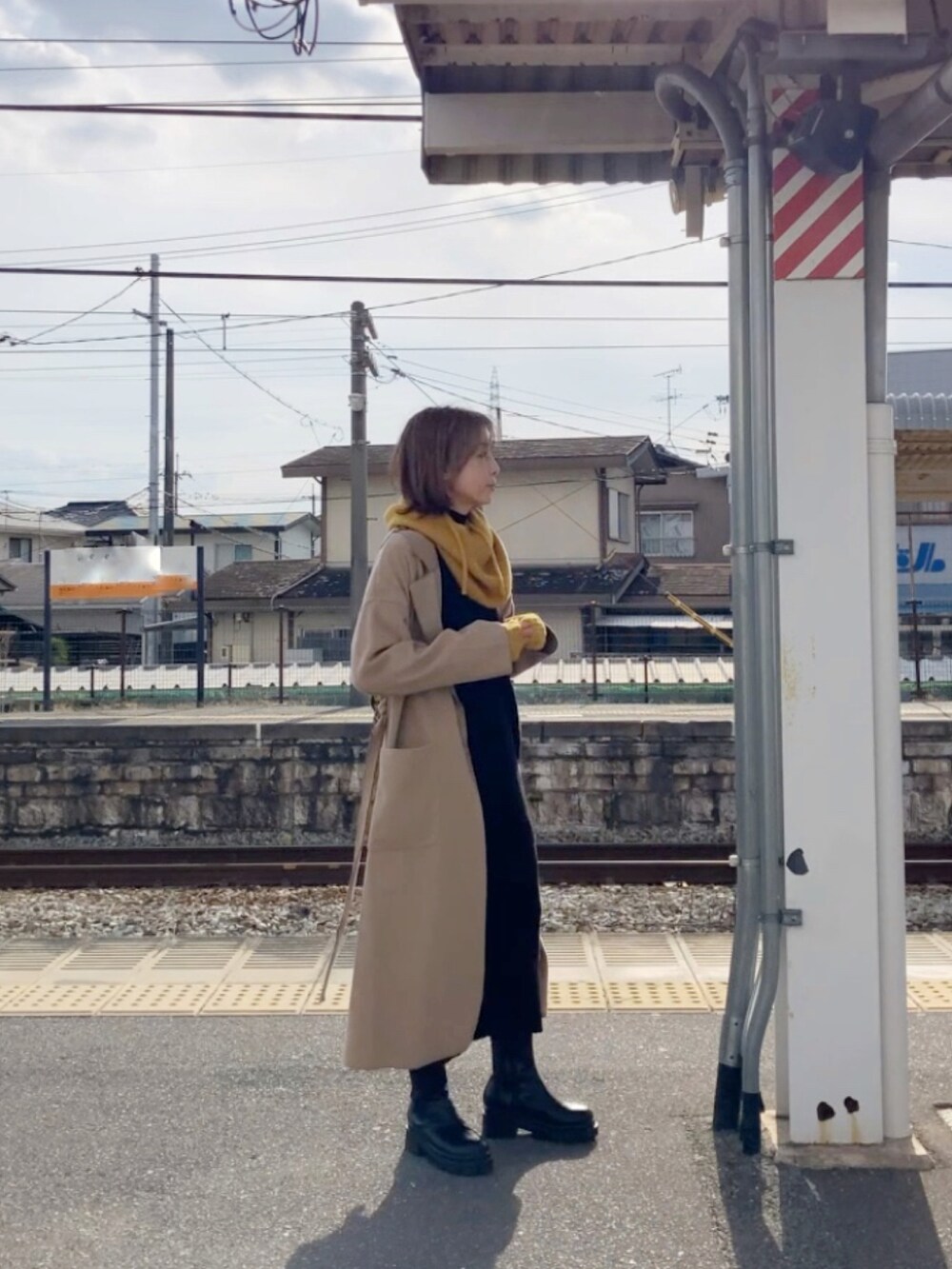 ベージュ系のジャケット/アウター、ブラック系のワンピース、ブラウン系のショルダーバッグを着用したレディースの冬コーディネートの4枚目の写真