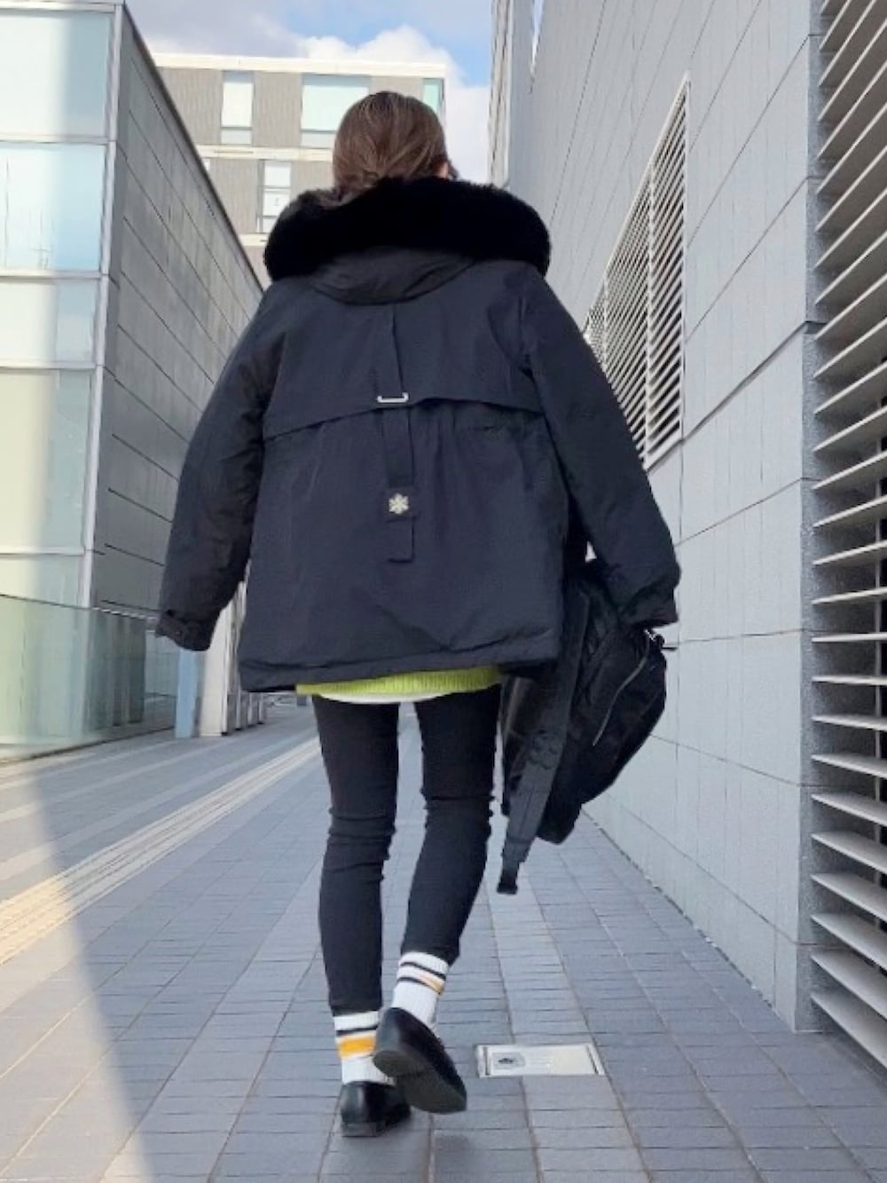 ブラック系のブルゾン、グリーン系のカーディガン/ボレロ、ブラック系のパンツを着用したレディースの冬コーディネートの3枚目の写真