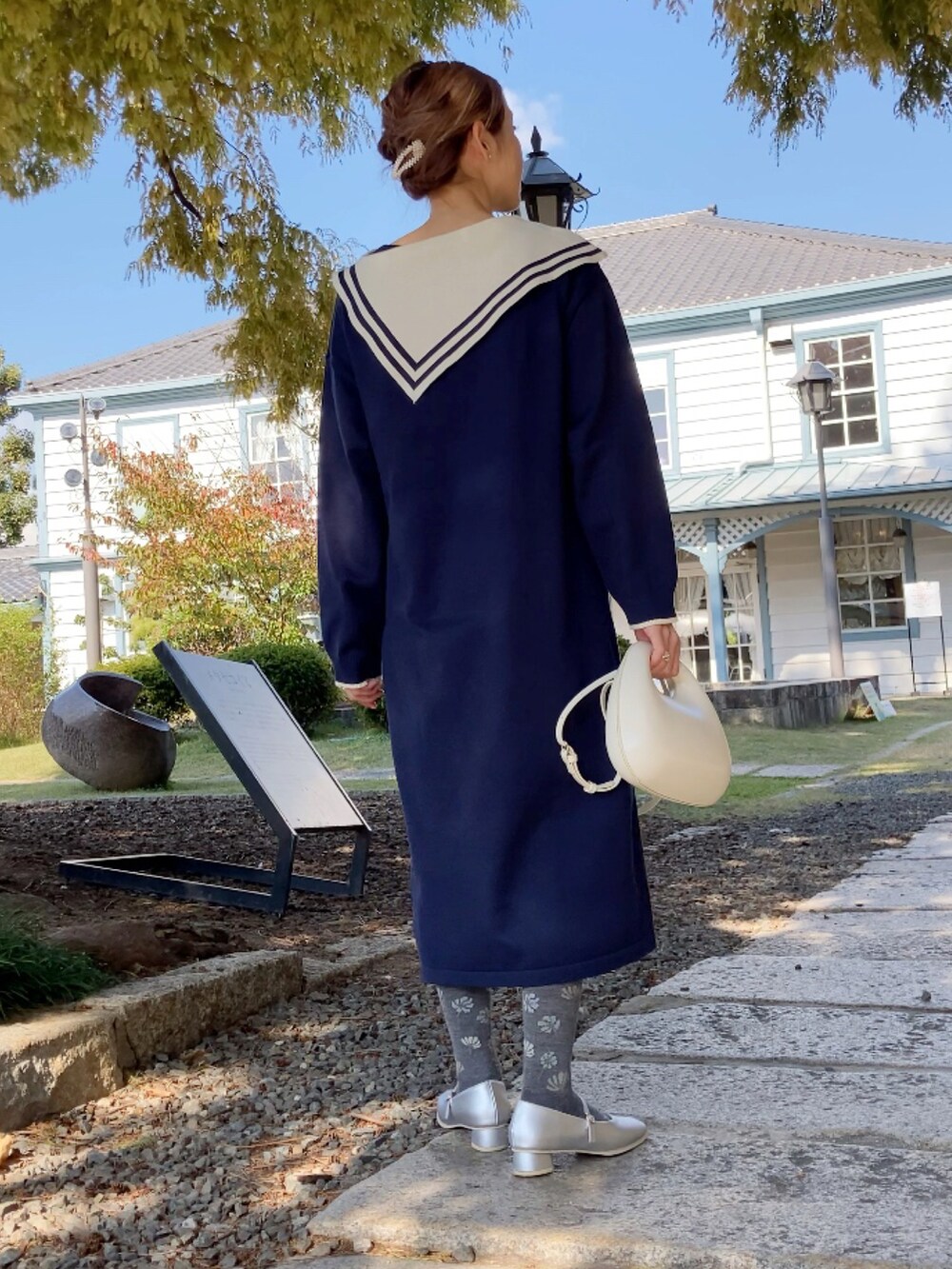 ブルー系のワンピース/ドレス、ホワイト系のバッグ、シルバー系のパンプスを着用したレディースの秋コーディネートの5枚目の写真