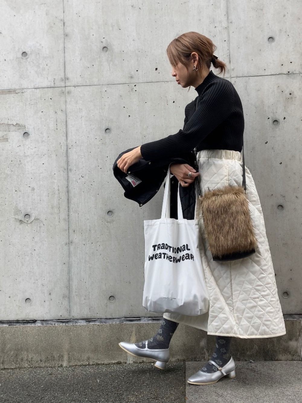 ブラック系のその他アウター、ホワイト系のトートバッグ、ブラック系のニット/セーターを着用したレディースの秋コーディネートの3枚目の写真