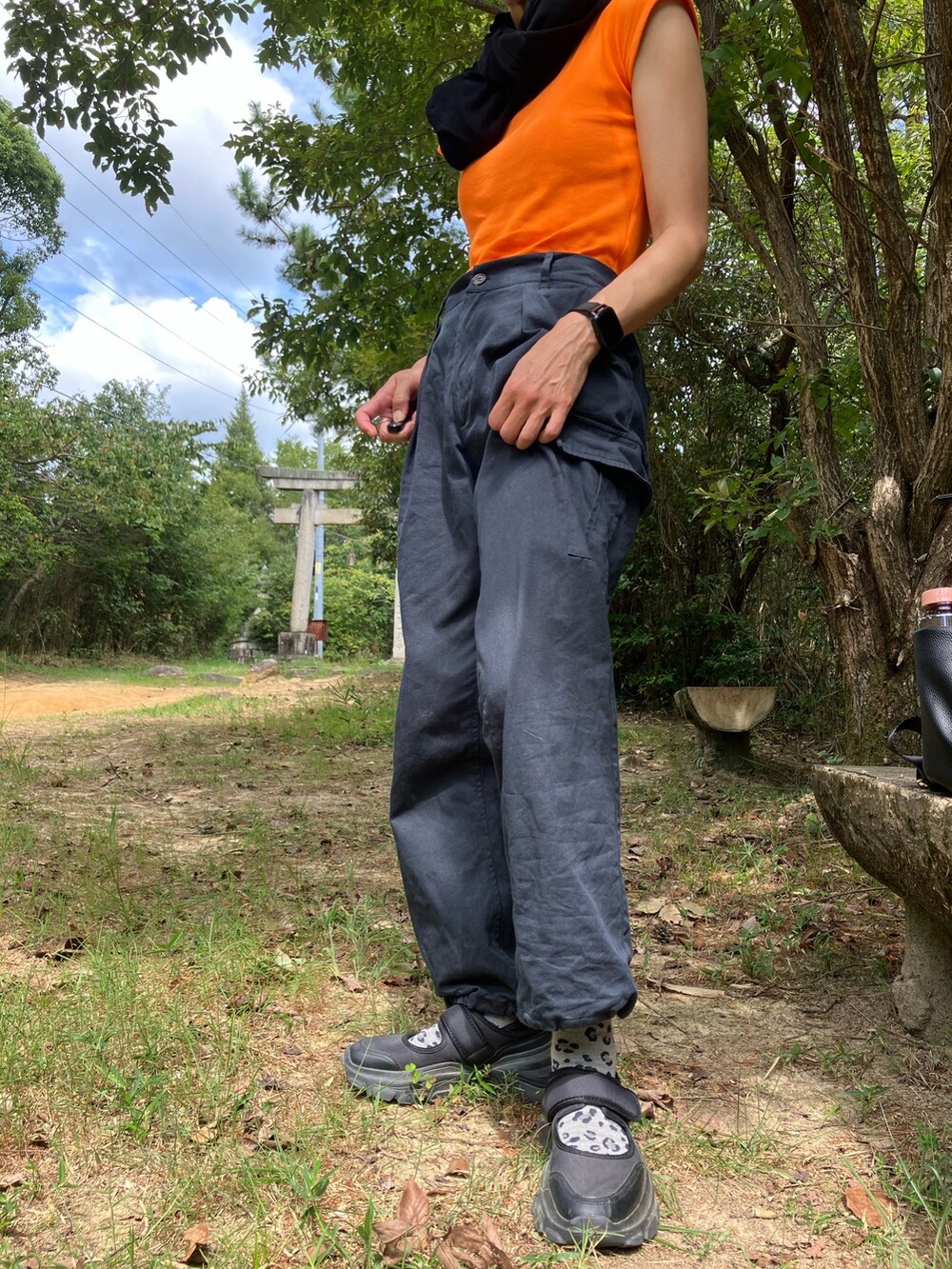 オレンジ系のTシャツ/カットソー、ブラック系のカーディガン/ボレロ、ブラック系のカーゴパンツを着用したレディースの秋コーディネートの3枚目の写真