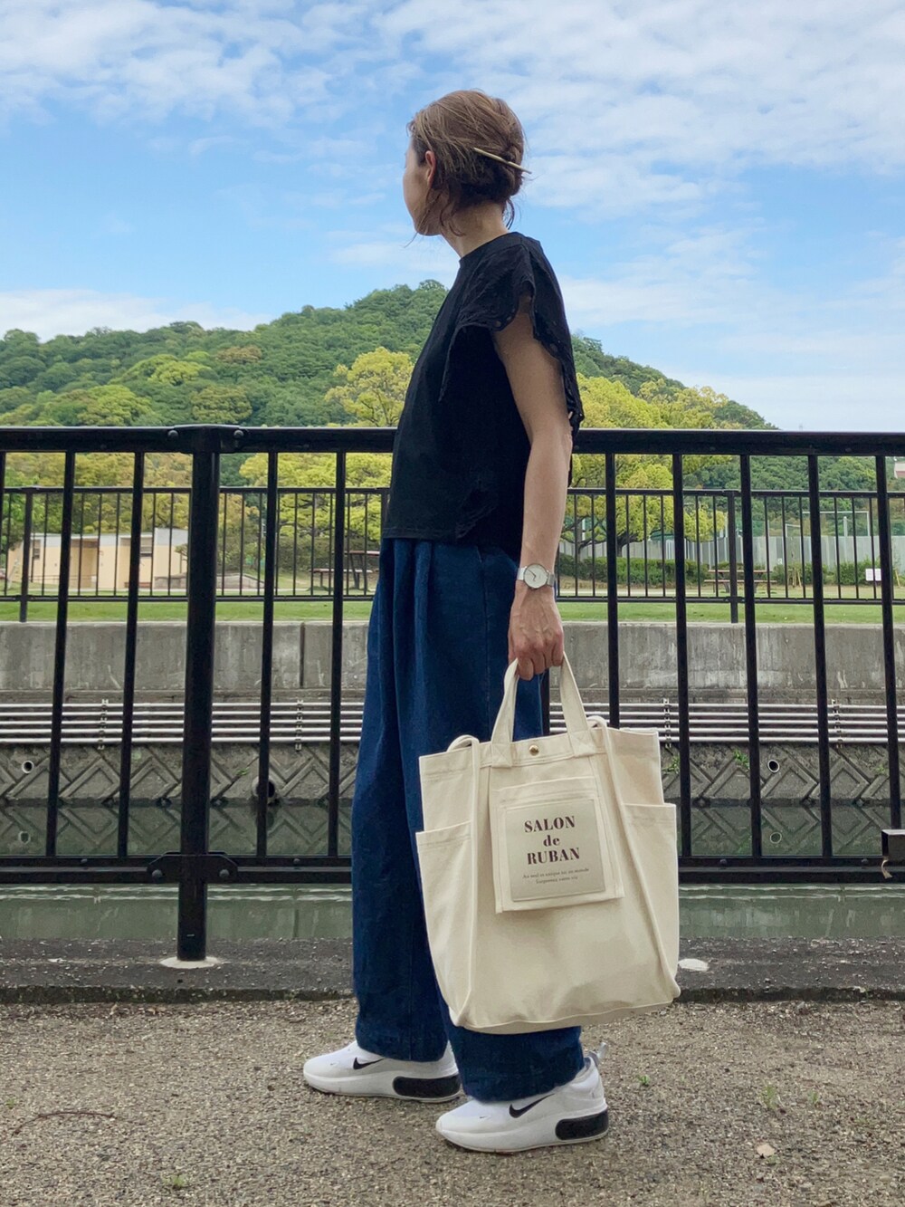 ブラック系のTシャツ/カットソー、ブルー系のデニムパンツ、ホワイト系のスニーカーを着用したレディースの春コーディネートの3枚目の写真