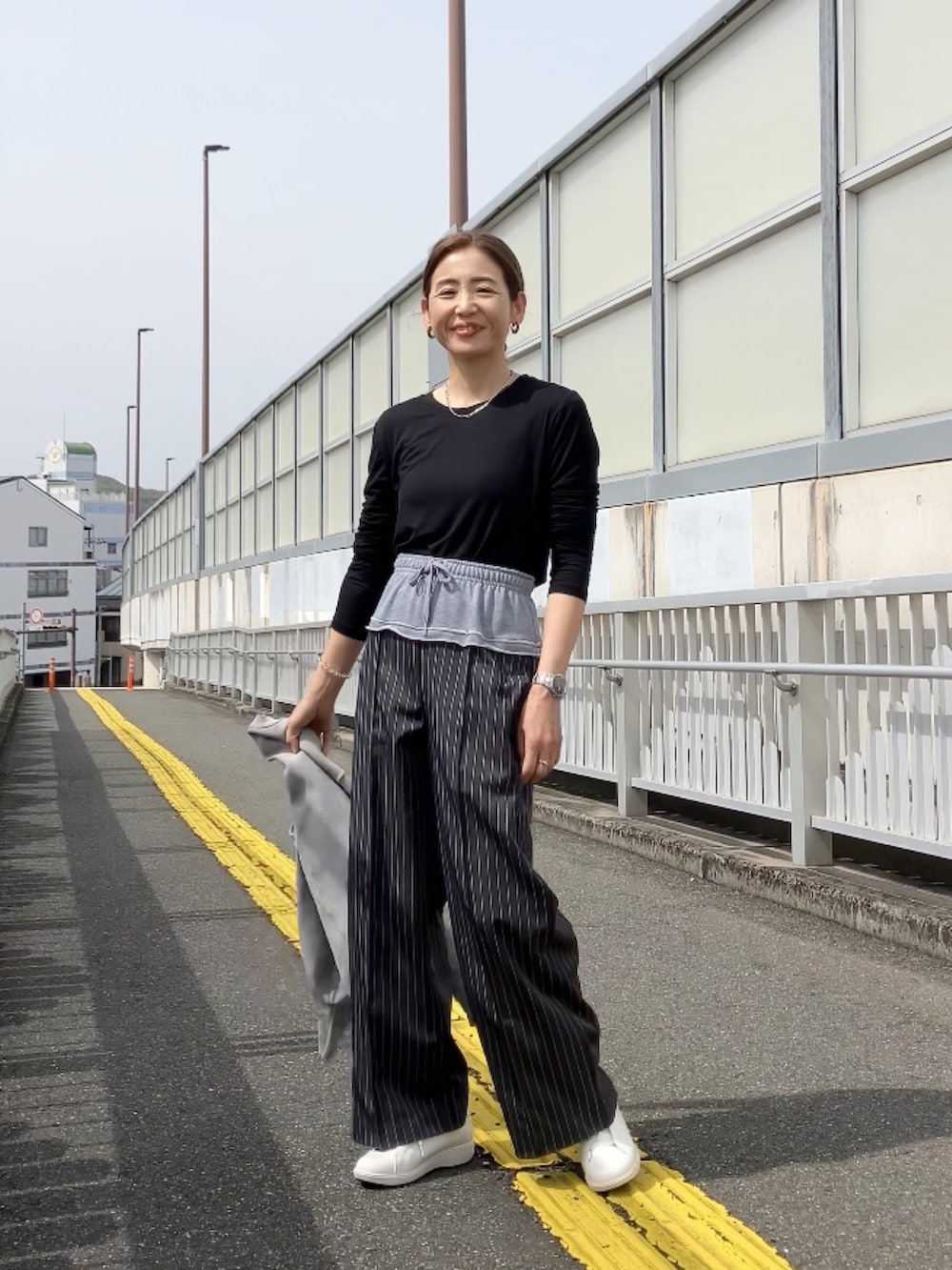 ブラック系のその他パンツ、ホワイト系のスニーカー、ブラック系のTシャツ/カットソーを着用したレディースの春コーディネートの2枚目の写真