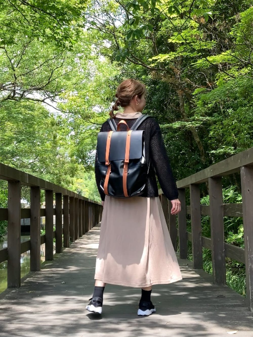 ベージュ系のワンピース、ブラック系のニット/セーター、ブラウン系のバックパック/リュックを着用したレディースの夏コーディネートの2枚目の写真