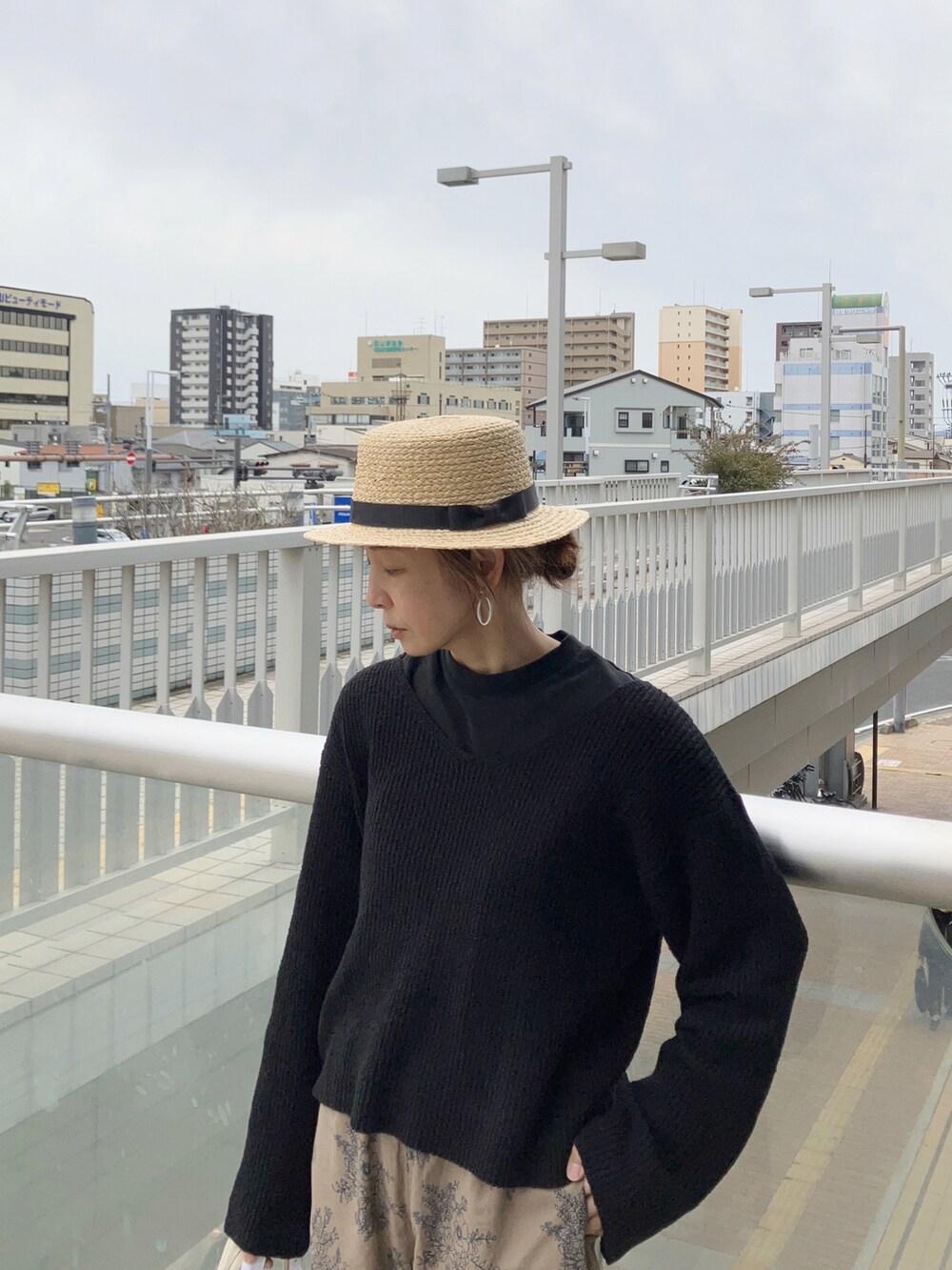 ベージュ系のパンツ、ブラック系のニット/セーター、ブラック系のサンダルを着用したレディースの春コーディネートの2枚目の写真