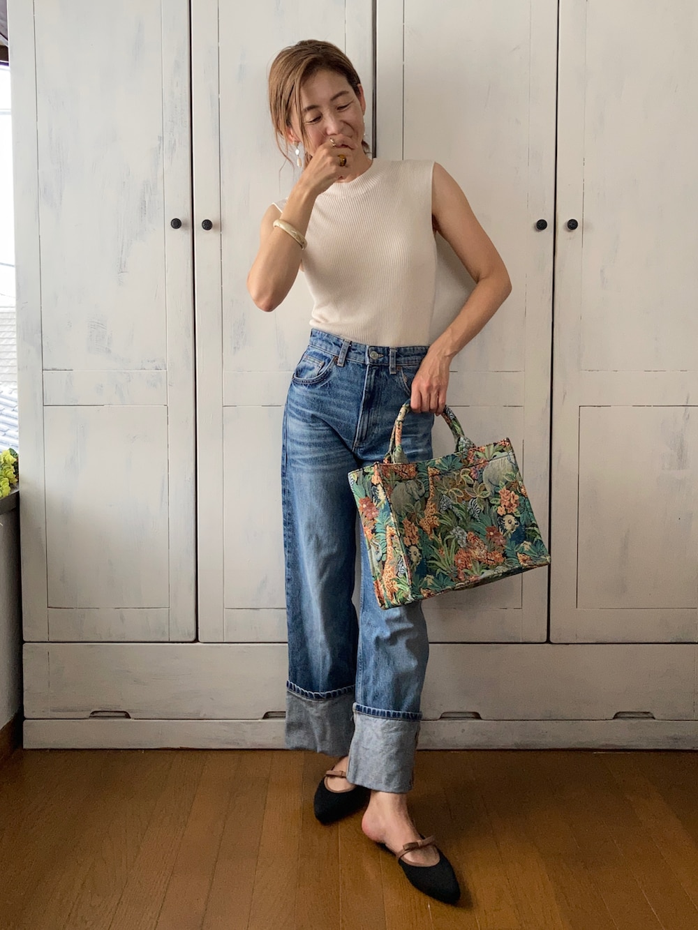 ホワイト系のニット/セーター、ブルー系のデニムパンツ、その他のトートバッグを着用したレディースの夏コーディネートの3枚目の写真