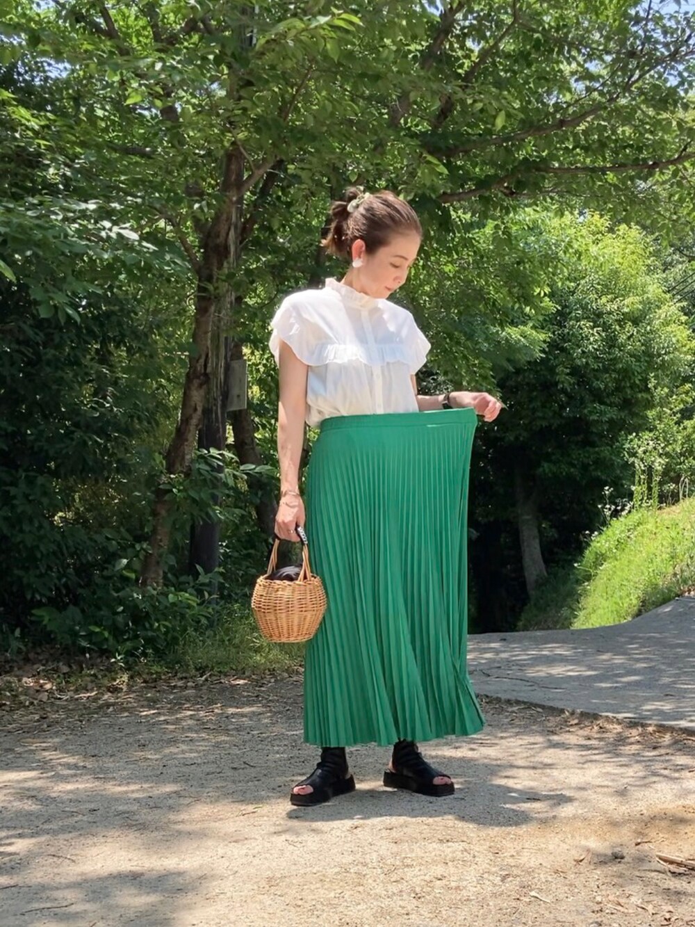 グリーン系のスカート、ホワイト系のシャツ/ブラウス、ブラック系のブーツを着用したレディースの夏コーディネートの4枚目の写真