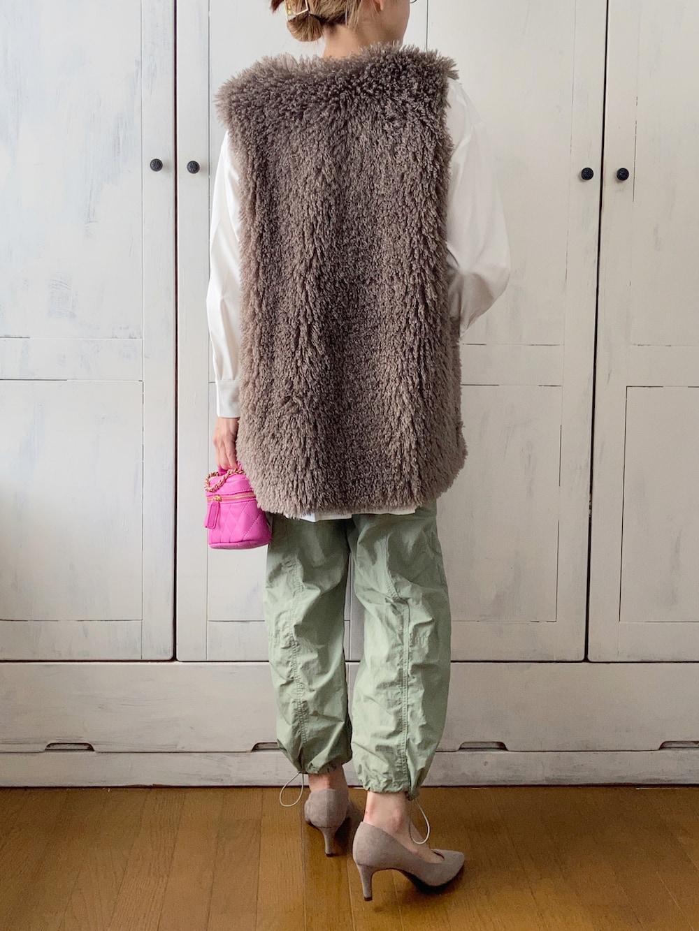 グレー系のベスト、ホワイト系のシャツ/ブラウス、グリーン系のその他パンツを着用したレディースの夏コーディネートの2枚目の写真