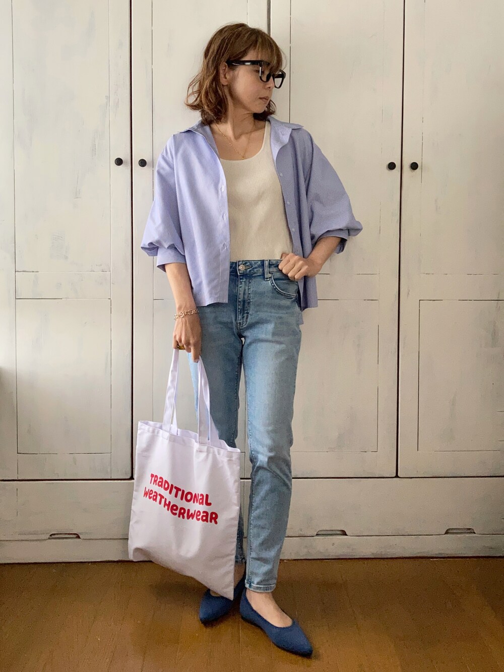 ブルー系のその他トップス、ブルー系のデニムパンツ、レッド系のトートバッグを着用したレディースの春コーディネートの2枚目の写真