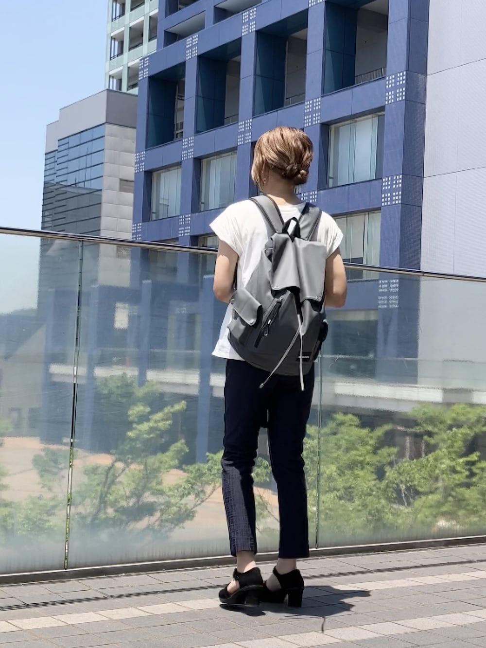グレー系のバックパック/リュック、ホワイト系のTシャツ/カットソー、ブルー系のスーツセットを着用したレディースの夏コーディネートの3枚目の写真