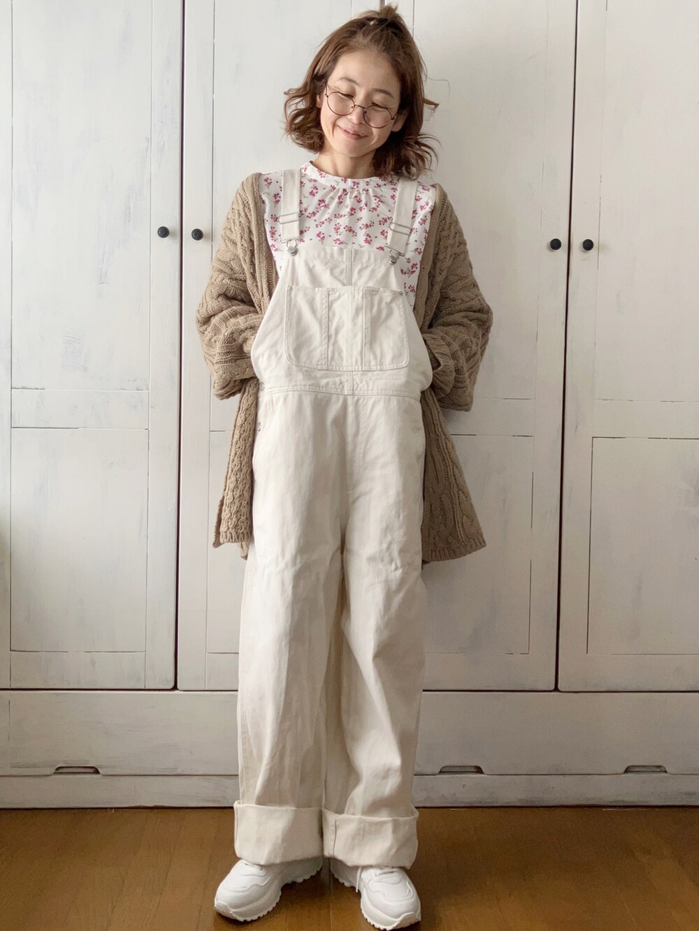 ホワイト系のダウンジャケット/コート、ベージュ系のカーディガン/ボレロ、ホワイト系のサロペット/オーバーオールを着用したレディースの冬コーディネートの2枚目の写真