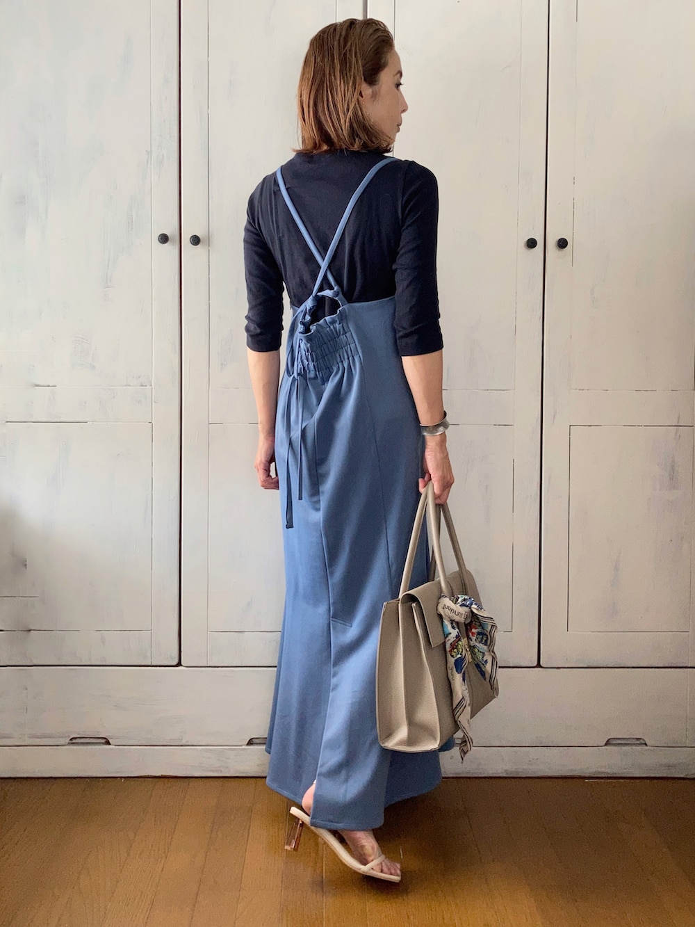 ブルー系のワンピース、ベージュ系のビジネスバッグ、ベージュ系のサンダルを着用したレディースの夏コーディネートの2枚目の写真