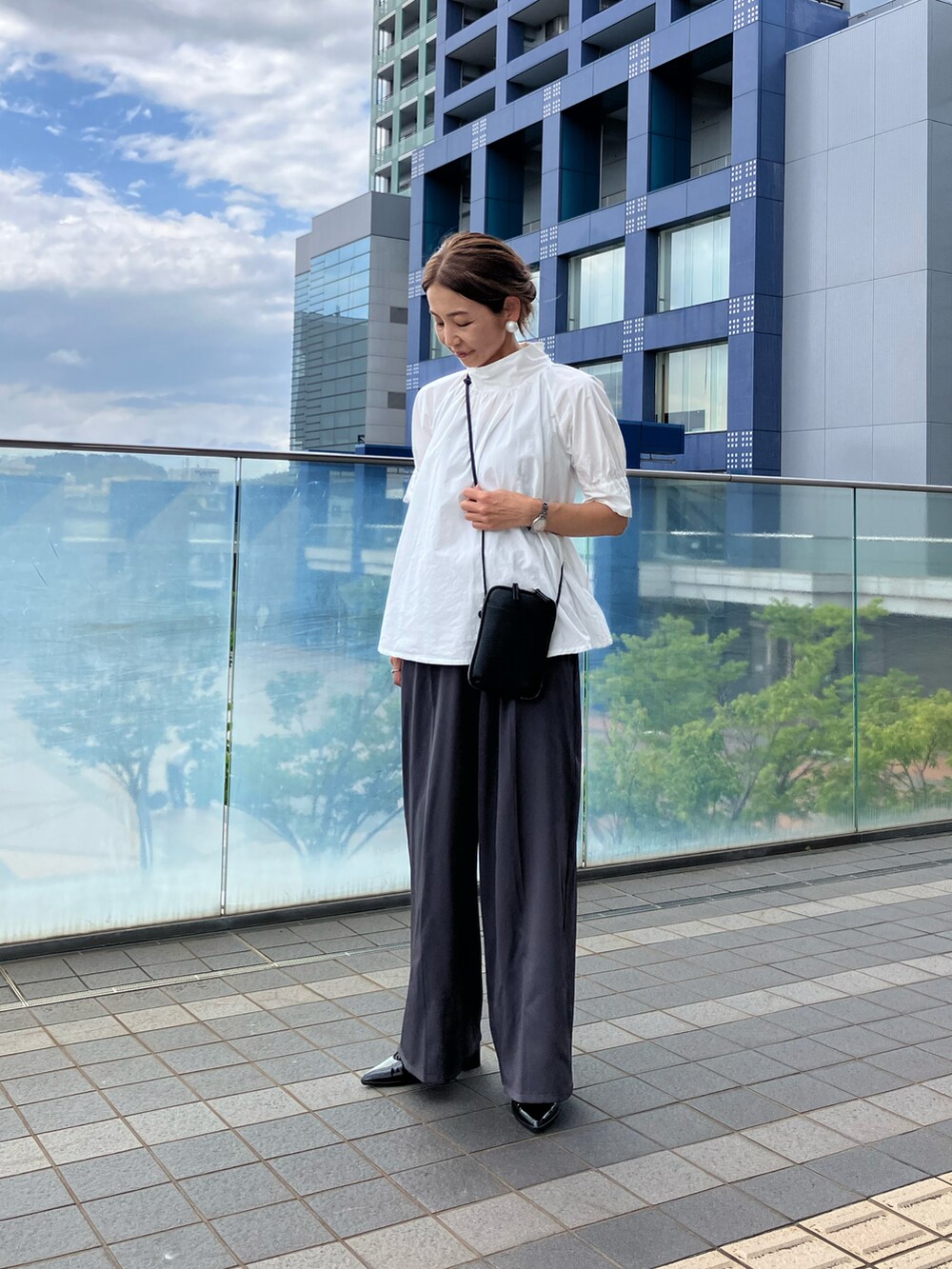 ホワイト系のシャツ/ブラウス、ブラック系のバッグ、ブラック系のシューズを着用したレディースの夏コーディネートの3枚目の写真