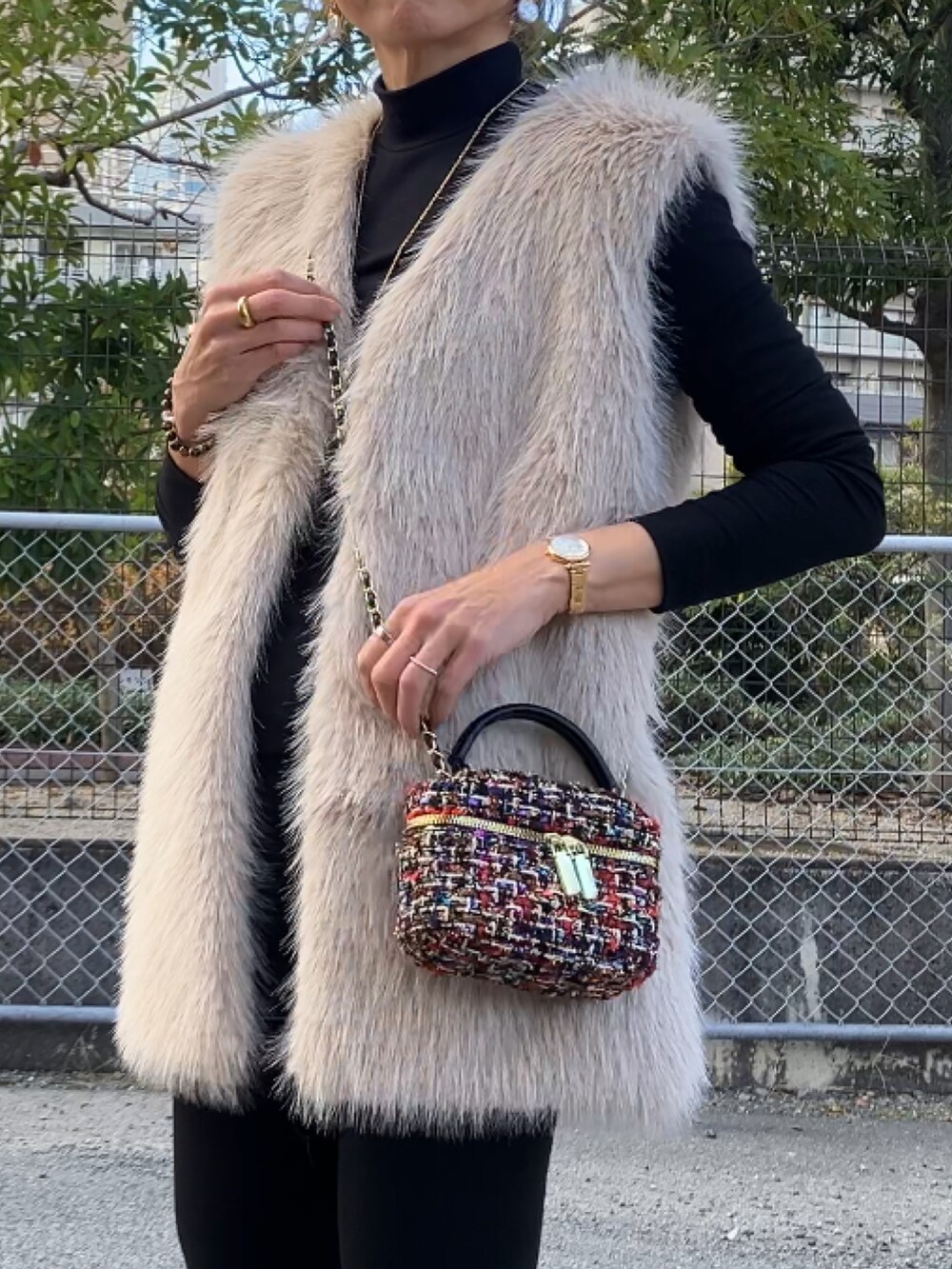 ブラック系のトップス、ベージュ系のベスト、その他のハンドバッグを着用したレディースの冬コーディネートの2枚目の写真