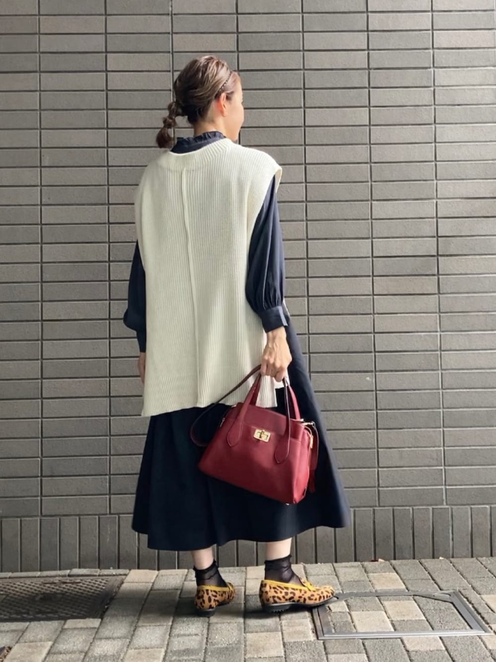 ホワイト系のベスト、ブラック系のシャツ/ブラウス、ブラック系のスカートを着用したレディースの春コーディネートの3枚目の写真