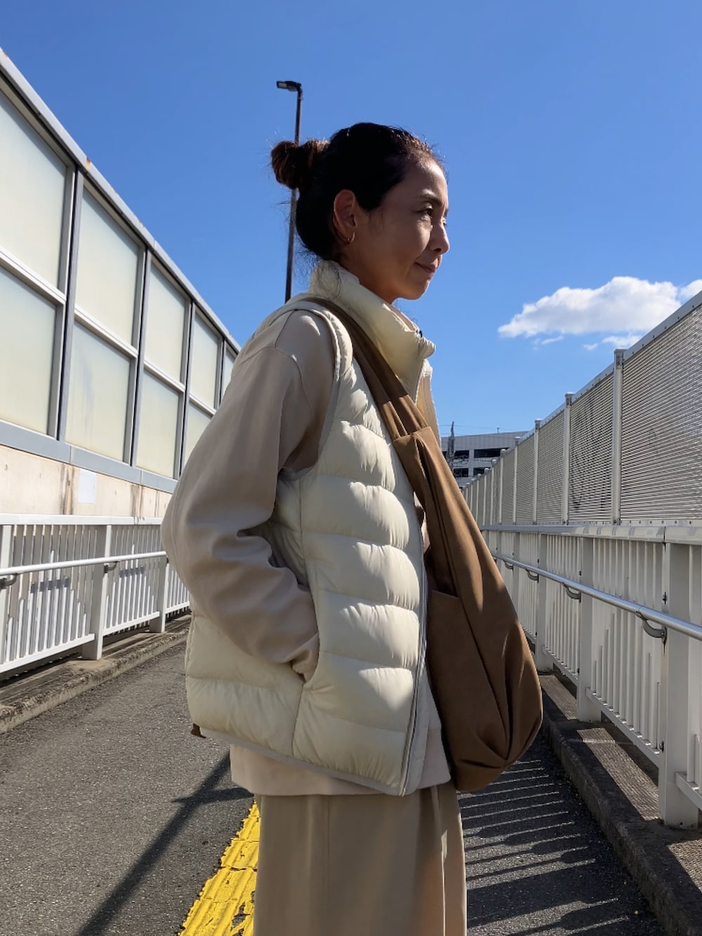 ホワイト系のダウンベストを着用したレディースの秋コーディネートの2枚目の写真