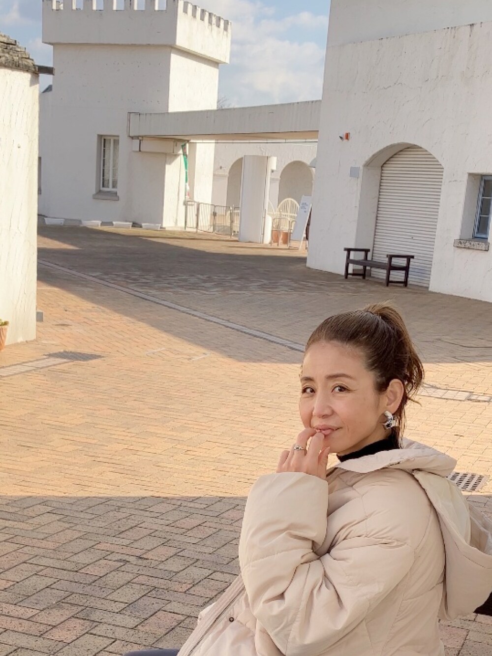 ホワイト系のダウンジャケット/コート、ブラック系のニット/セーター、グレー系のその他パンツを着用したレディースの冬コーディネートの5枚目の写真