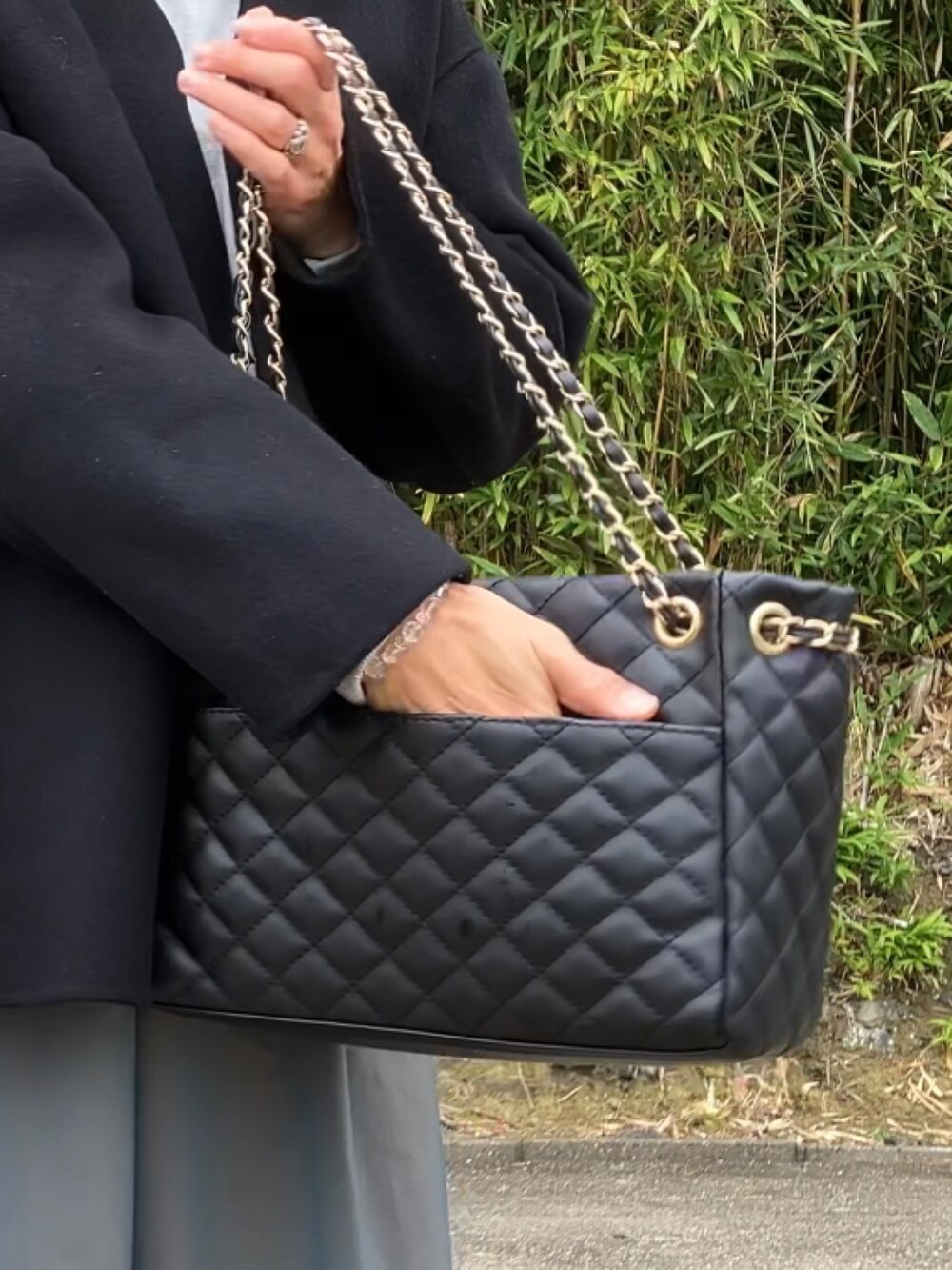 ブラック系のボストンバッグ、グレー系のスウェット、グリーン系のスカートを着用したレディースの冬コーディネートの3枚目の写真