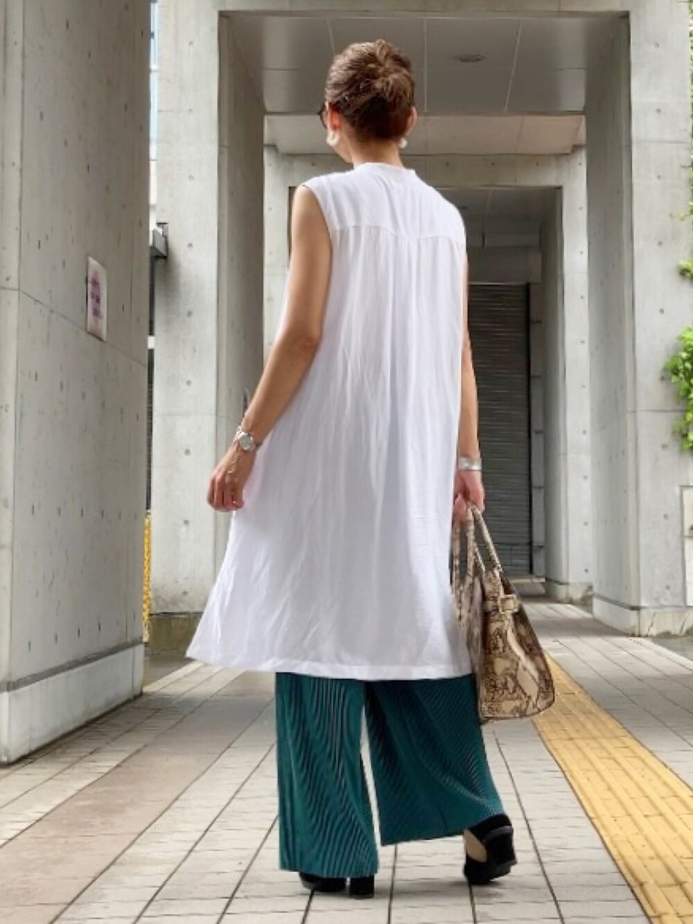 グリーン系のパンツ、ホワイト系のシャツ/ブラウス、ブラック系のカーディガン/ボレロを着用したレディースの夏コーディネートの3枚目の写真