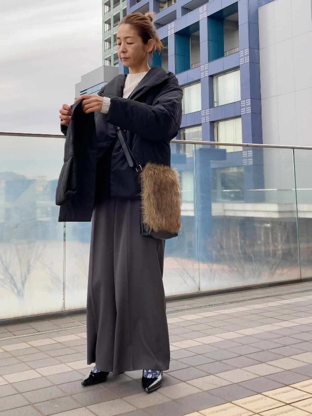 ブラック系のダウンジャケット/コート、ホワイト系のTシャツ/カットソー、グレー系のその他パンツを着用したレディースの冬コーディネートの4枚目の写真