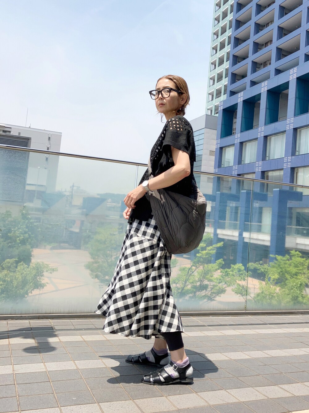 ブラック系のベスト、ブラック系のワンピース、ブラック系のサンダルを着用したレディースの夏コーディネートの2枚目の写真