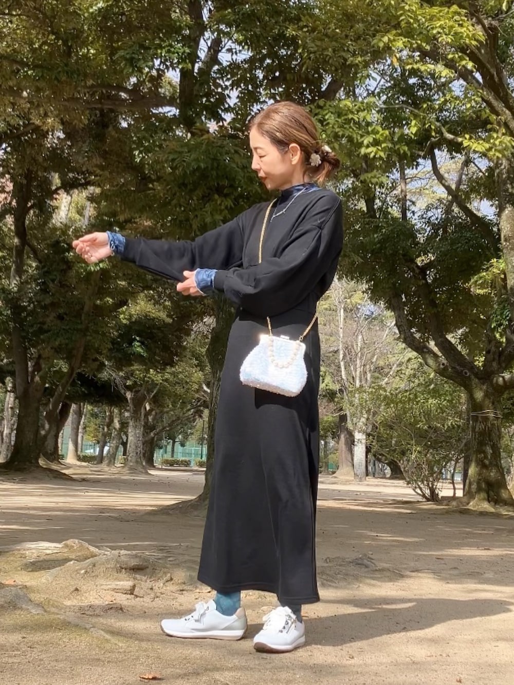 ブラック系のワンピース、ブルー系のTシャツ/カットソー、ホワイト系のハンドバッグを着用したレディースの冬コーディネートの5枚目の写真