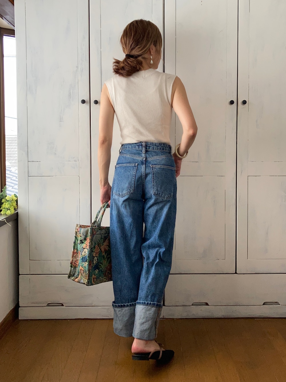 ホワイト系のニット/セーター、ブルー系のデニムパンツ、その他のトートバッグを着用したレディースの夏コーディネートの2枚目の写真