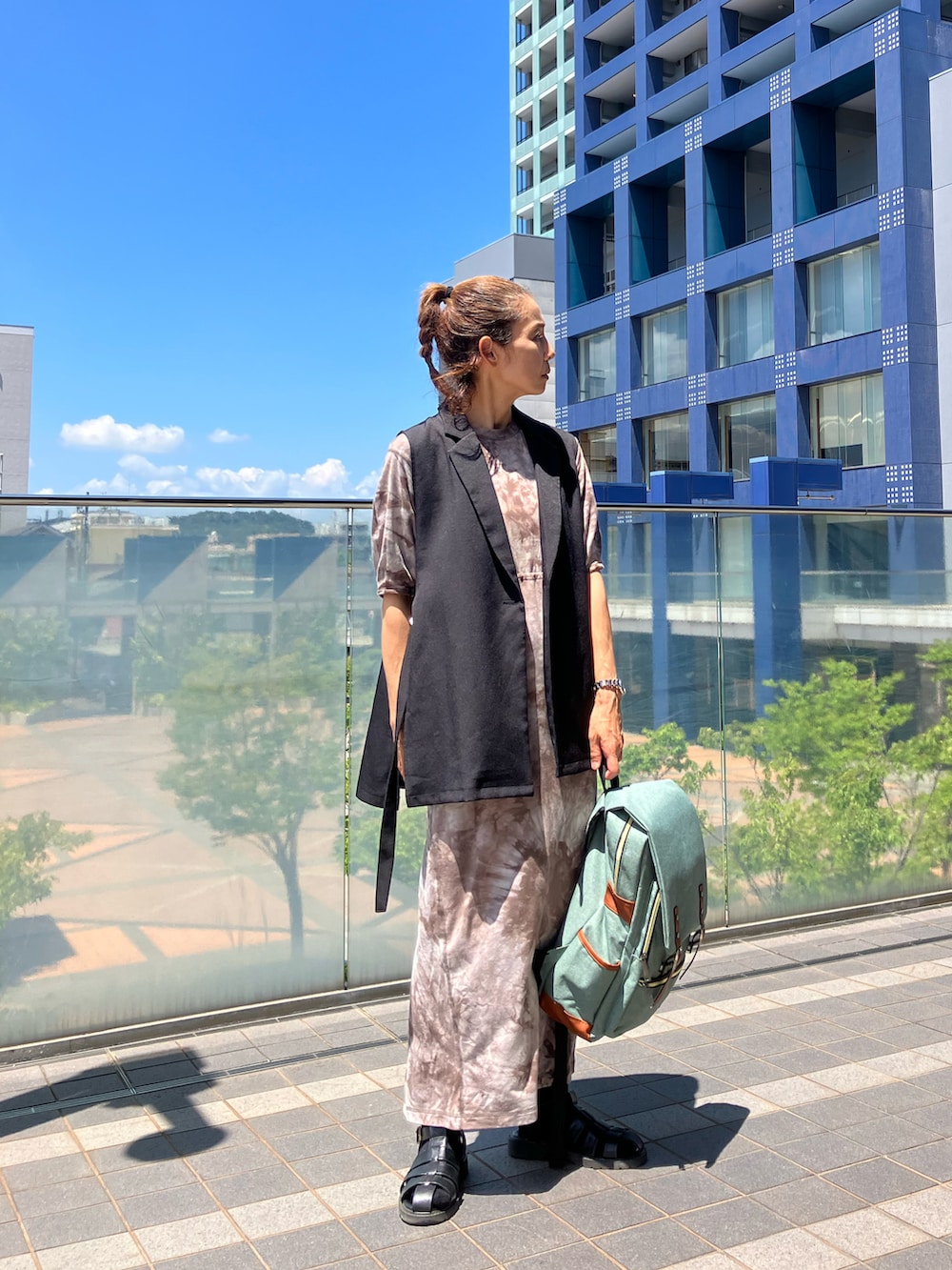 ブラウン系のワンピース、グリーン系のバックパック/リュック、ブラック系のサンダルを着用したレディースの夏コーディネートの2枚目の写真