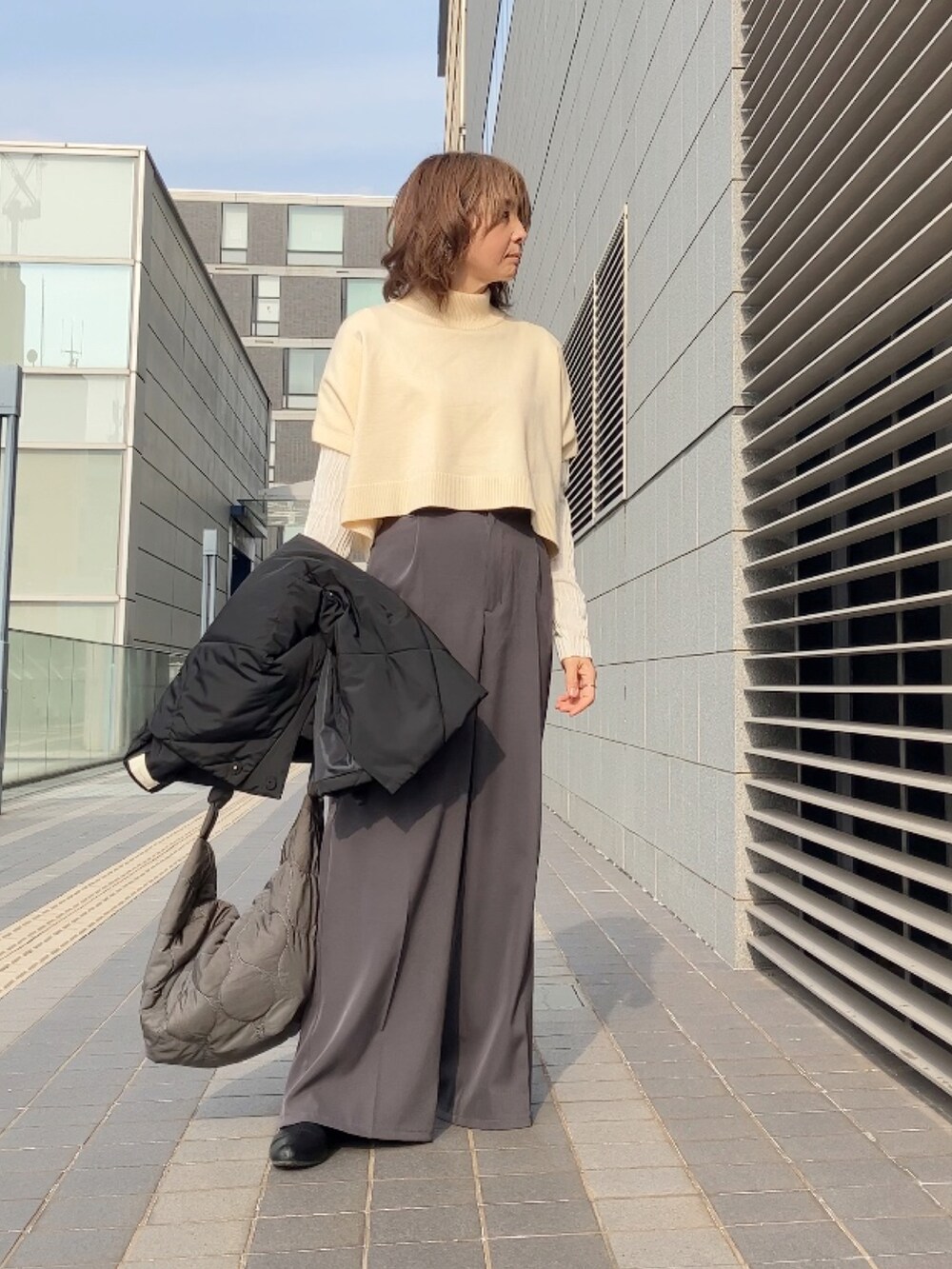 ブラック系のダウンジャケット/コート、ホワイト系のワンピース、グレー系のその他パンツを着用したレディースの冬コーディネートの3枚目の写真